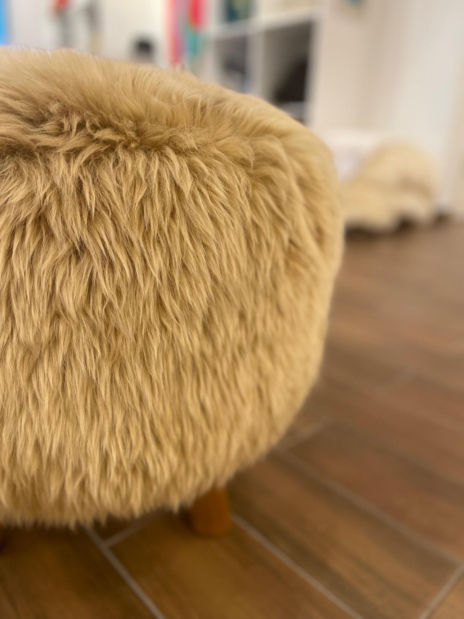 This special made pouf is reminiscent of the notorious Polish Cossack hats. The wooly Australian sheep's wool is soft and plush. The 4 legs are hand carved and are sturdy enough to hold the weight of 2 people. The shape and design are timeless.