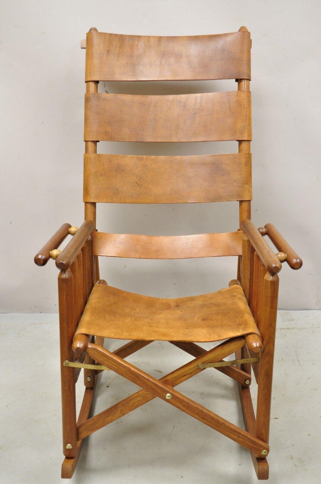 Costa Rican Campaign Style teak brown leather folding rocker rocking chair. Item features hick brown leather straps, solid teak wood folding frame, original stamp, very nice vintage item, quality craftsmanship, great style and form. Circa Mid to