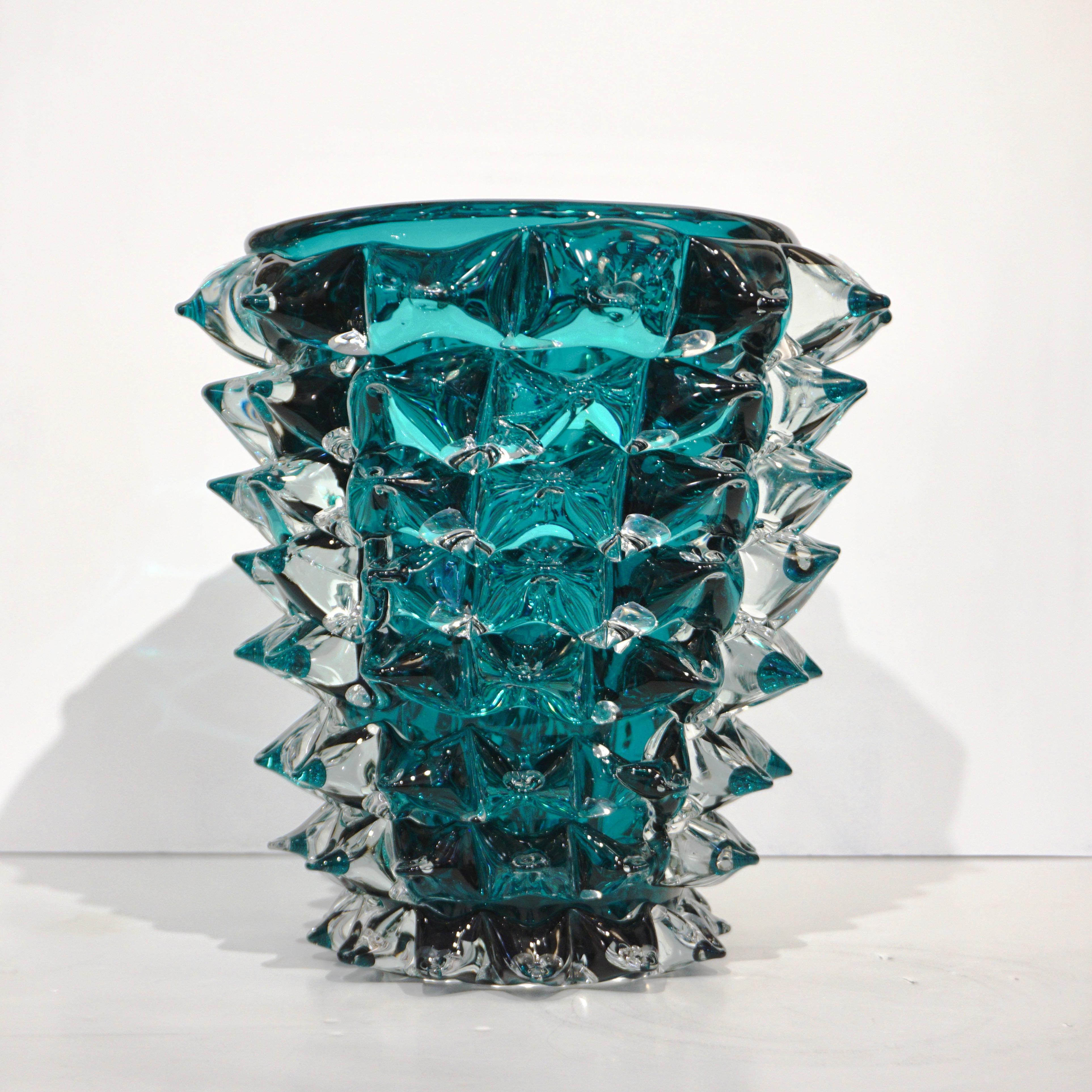 A very elegant and glowing 21st century Italian vase by Sergio Costantini, handcrafted modern sculpture in teal aqua blue-green Murano glass overlaid in crystal clear and decorated with the high skilled rostrato technique to produce a spike design.