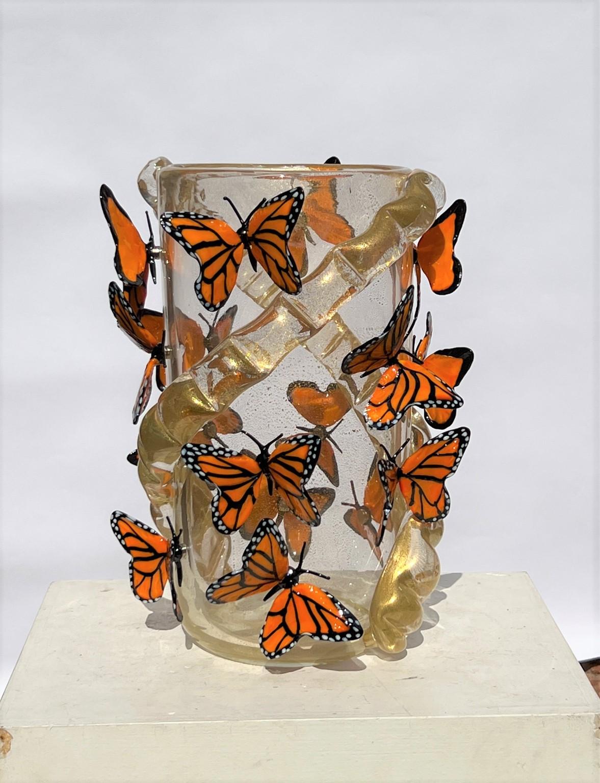 Vase en verre soufflé de Murano fait à la main avec de véritables feuilles d'or 24kt et des papillons monarques attachés avec un aimant. Le vase contient 16 papillons monarques.
Vase moderne idéal pour un environnement moderne et rustique