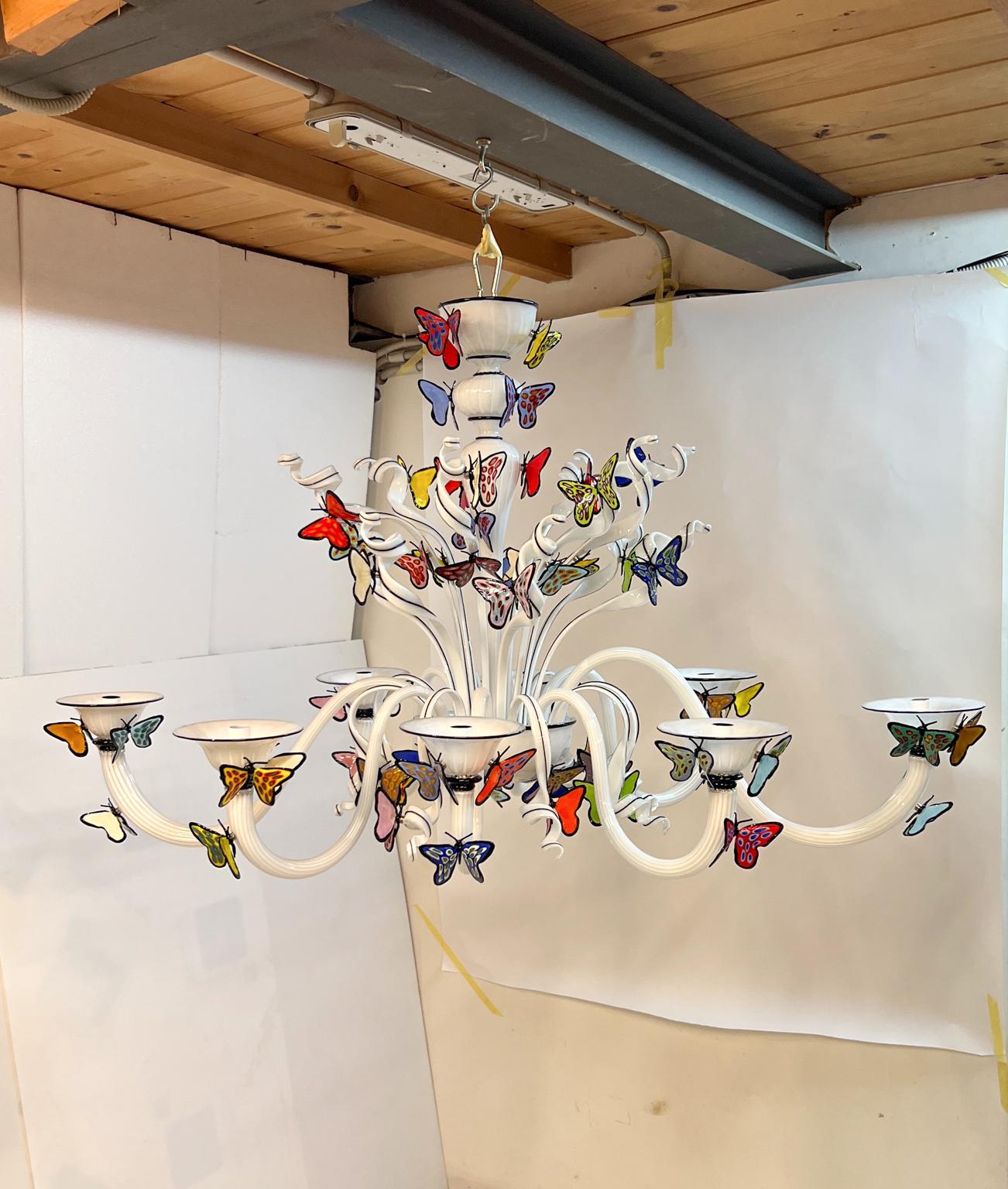 Lustre en verre de Murano blanc et noir fait à la main avec 63 papillons multicolores transparents attachés avec un aimant. 
Lustre à 8 lumières attaque E26 / 27. Possibilité de modifier la quantité de lumières, la taille et la forme à votre