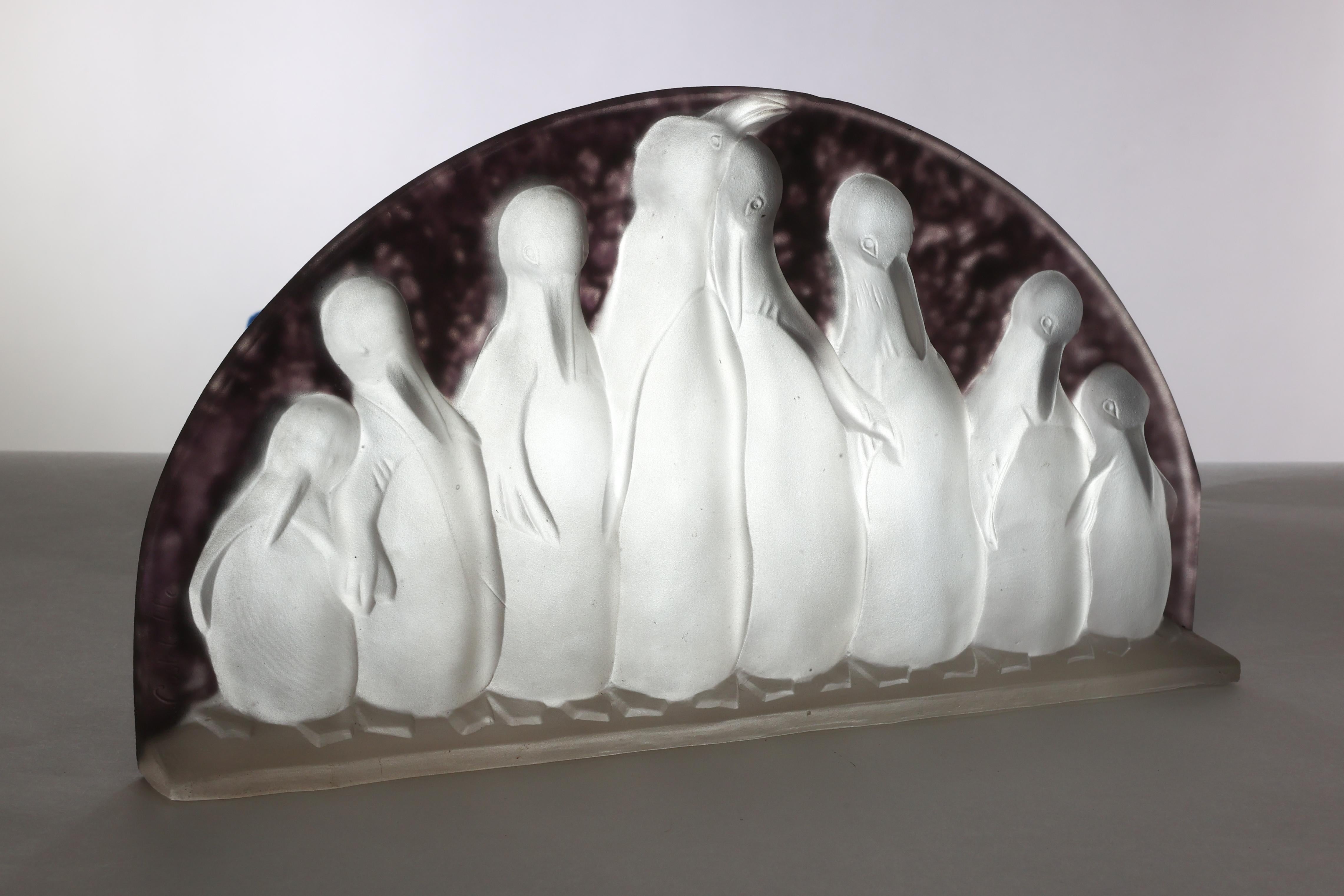 Verreries de Costebelle.

An Art Deco half-moon frosted opalescent glasswork depicting a colony of penguins.

Signed Costebelle on the left side of the glass