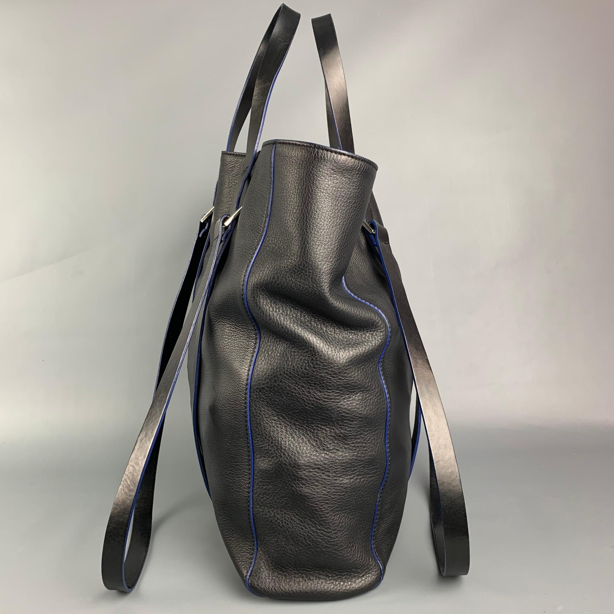 CoSTUME NATIONAL tote bag comes in a black pebble grain leather featuring top handles, shoulder straps, silver tone hardware, blue trim, and a seperate computer bag. 

Very Good Pre-Owned Condition.
Original Retail Price: