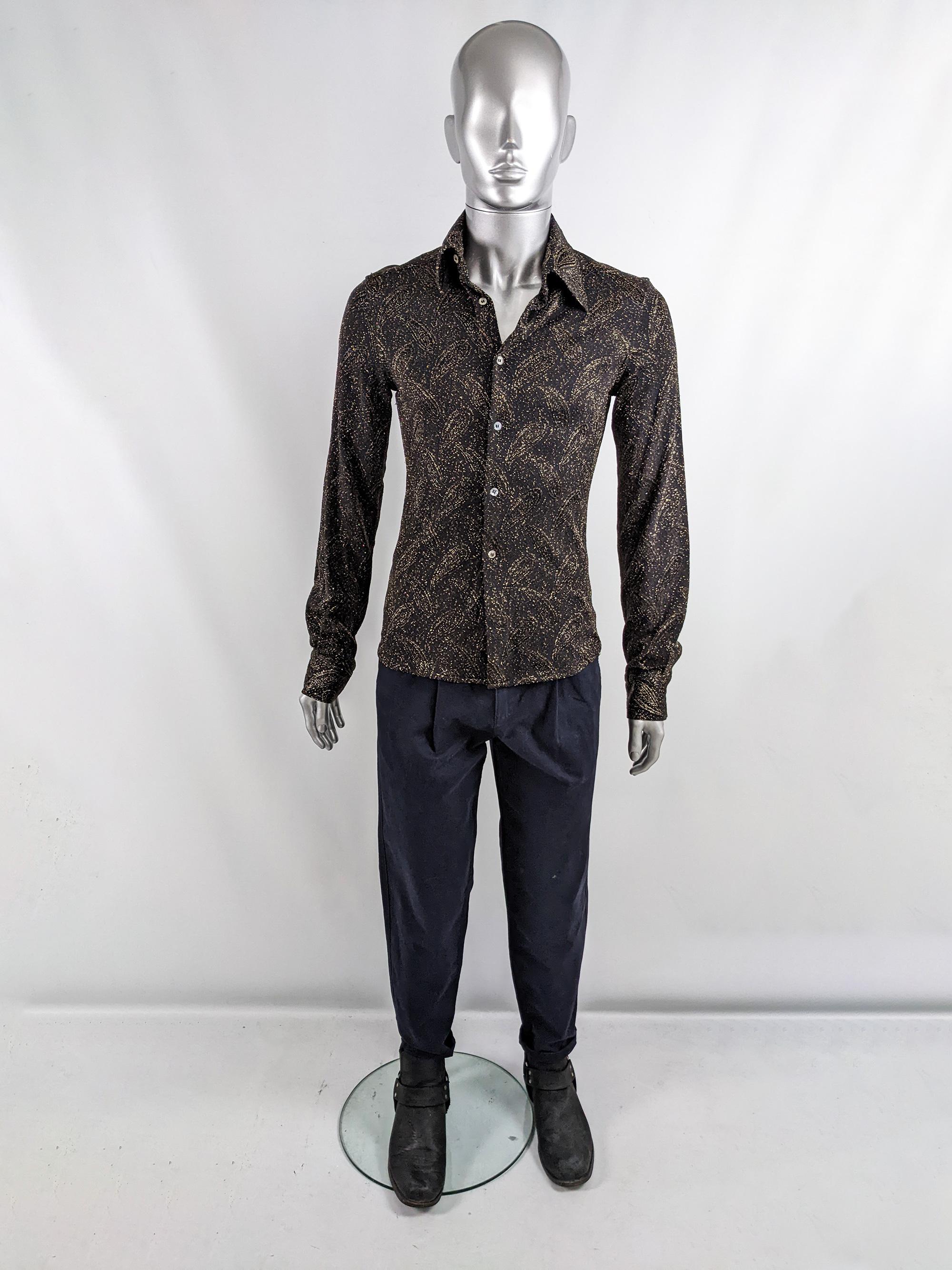 A stylish vintage mens party shirt from the late 90s/ early 2000s by luxury Italian label, Costume National. In a black jersey fabric with a gold lurex brocade throughout creating a 70s style paisley pattern. It has long sleeves and mother of pearl