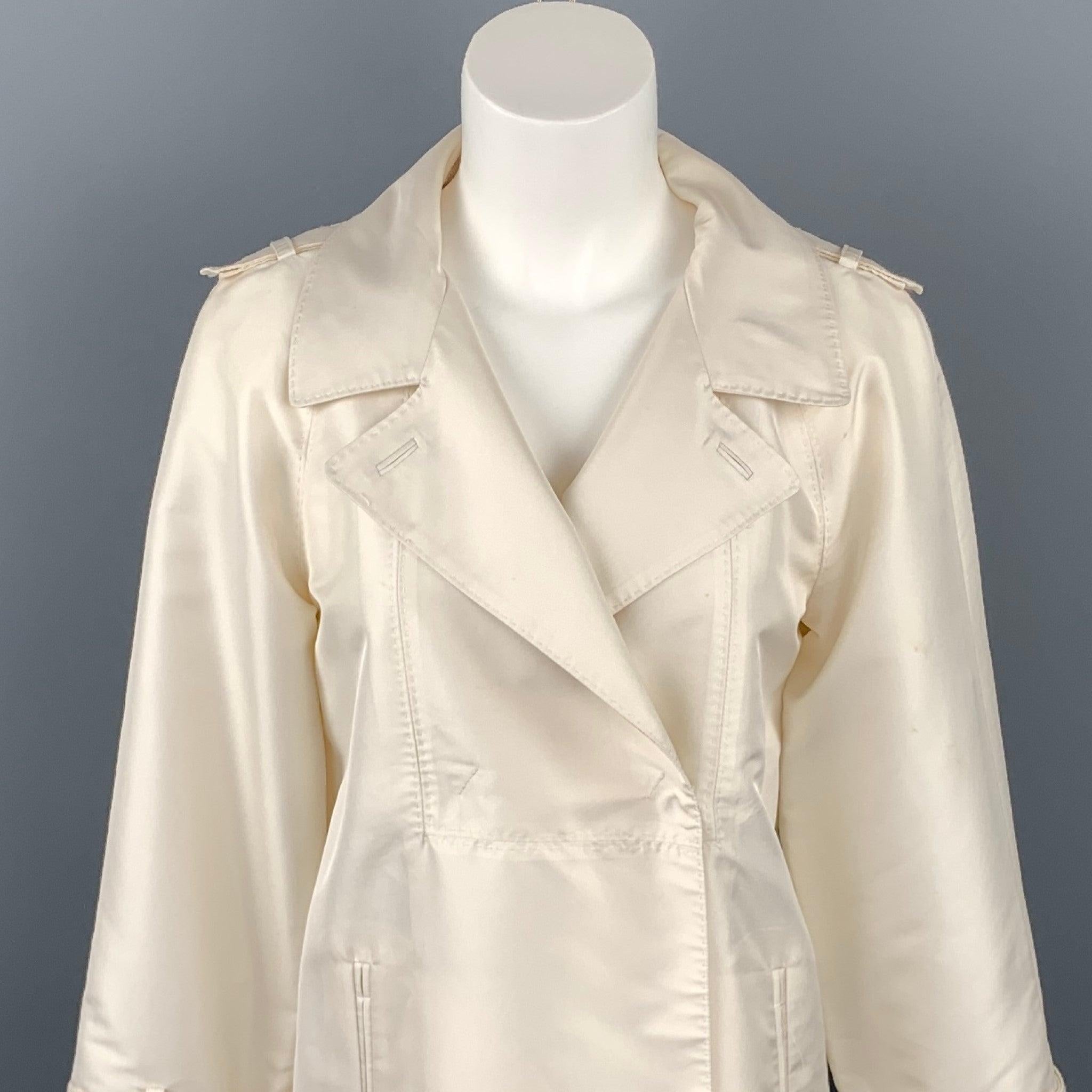 La veste CoSTUME NATIONAL est en polyester sergé crème avec une demi-doublure. Elle présente un revers à cran, des épaulettes, des poches fendues et une fermeture cachée à double boutonnage. Décoloration sur l'ensemble du document. Fabriqué en