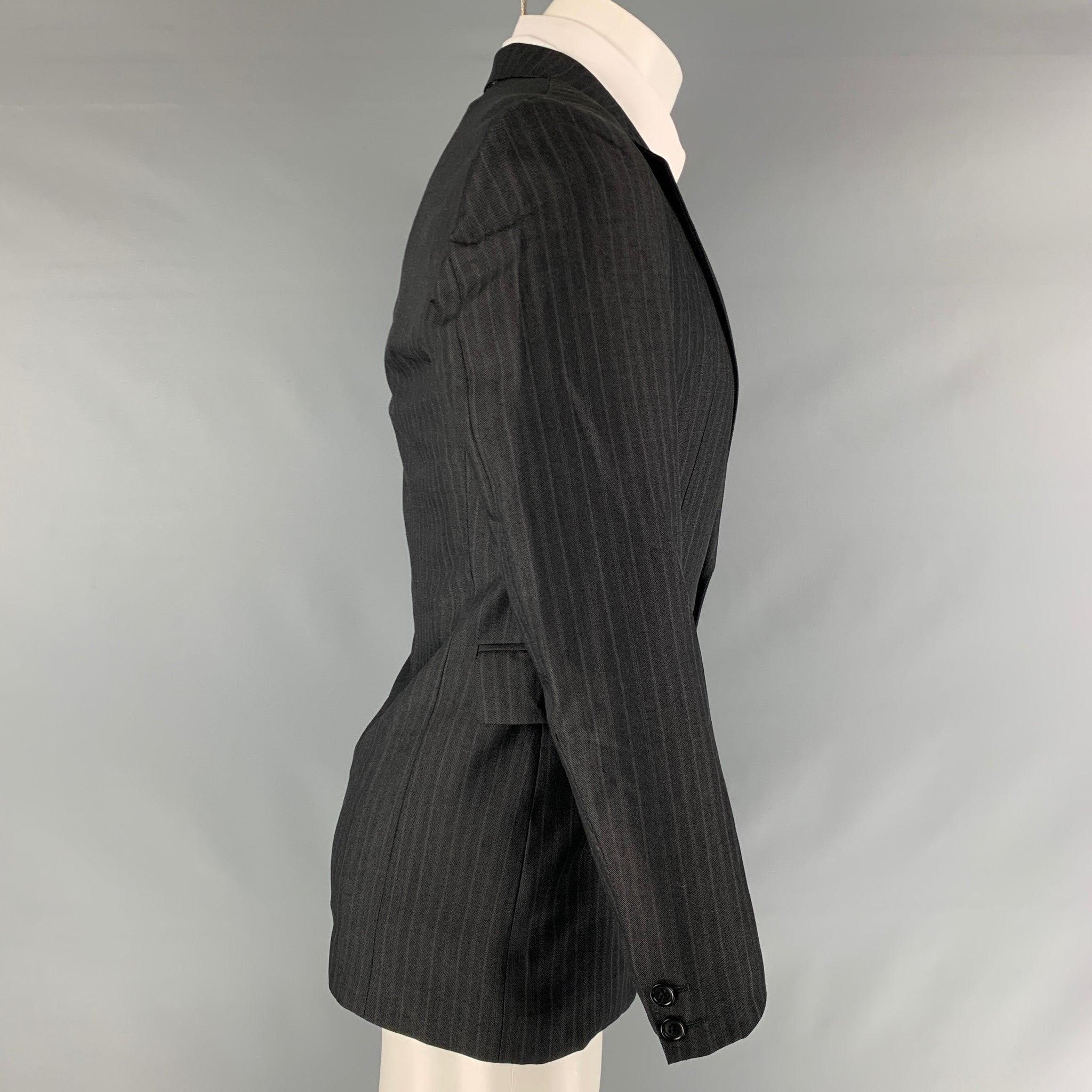 CoSTUME NATIONAL sport coat comes in a black stripped wool blend woven material featuring a notch lapel, flap pockets, and a double button closure. Made in Italy.Excellent Pre- Owned Material. 

Marked:   38 

Measurements: 
 
Shoulder: 16.5 inches