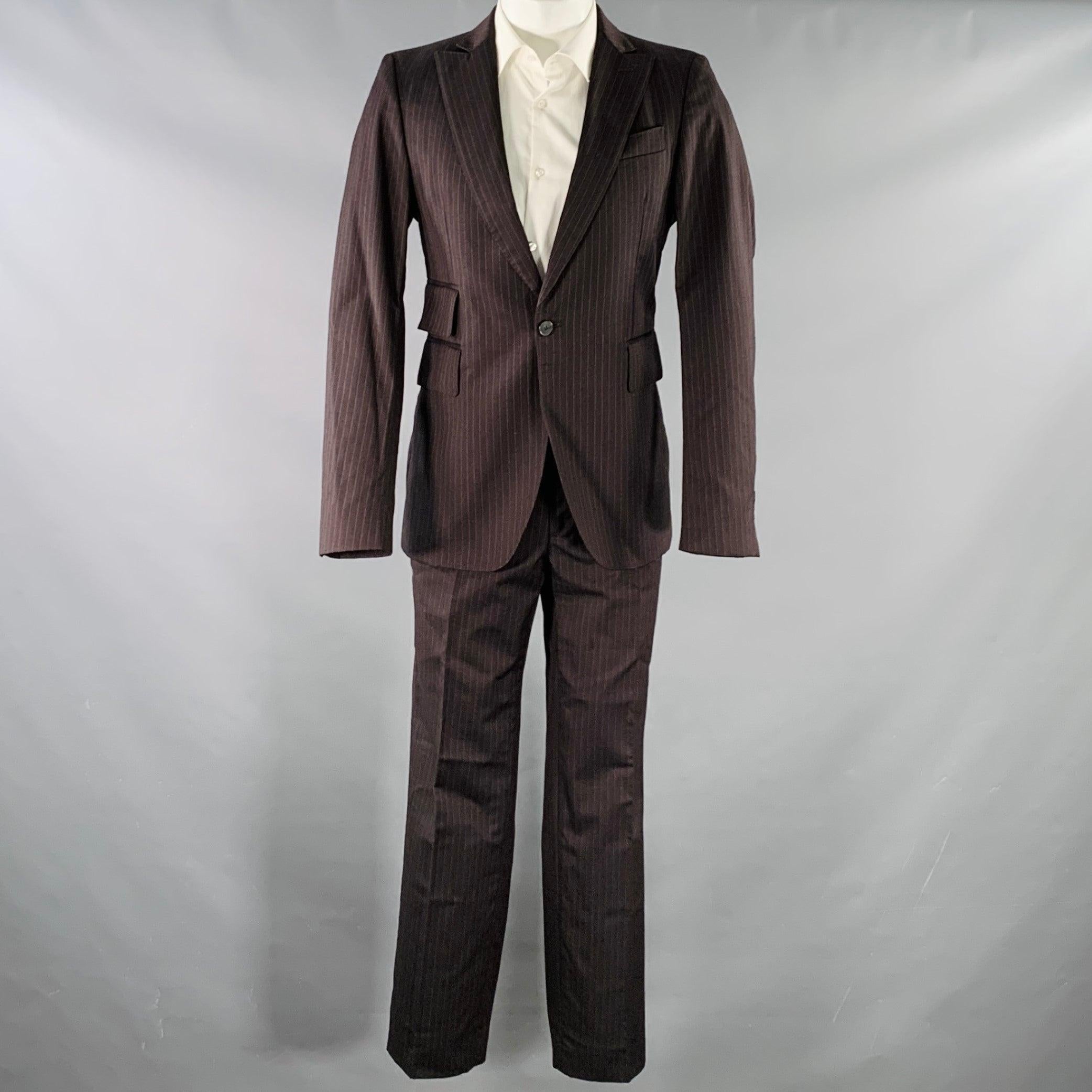 CoSTUME NATIONAL Anzug
in brauner und grauer Nadelstreifenwolle, bestehend aus einem einreihigen Sportmantel mit Revers und passender Hose mit flacher Vorderseite, in ausgezeichnetem Zustand. 

Markiert:   IT 48 

Abmessungen: 
  -JackeSchulter: