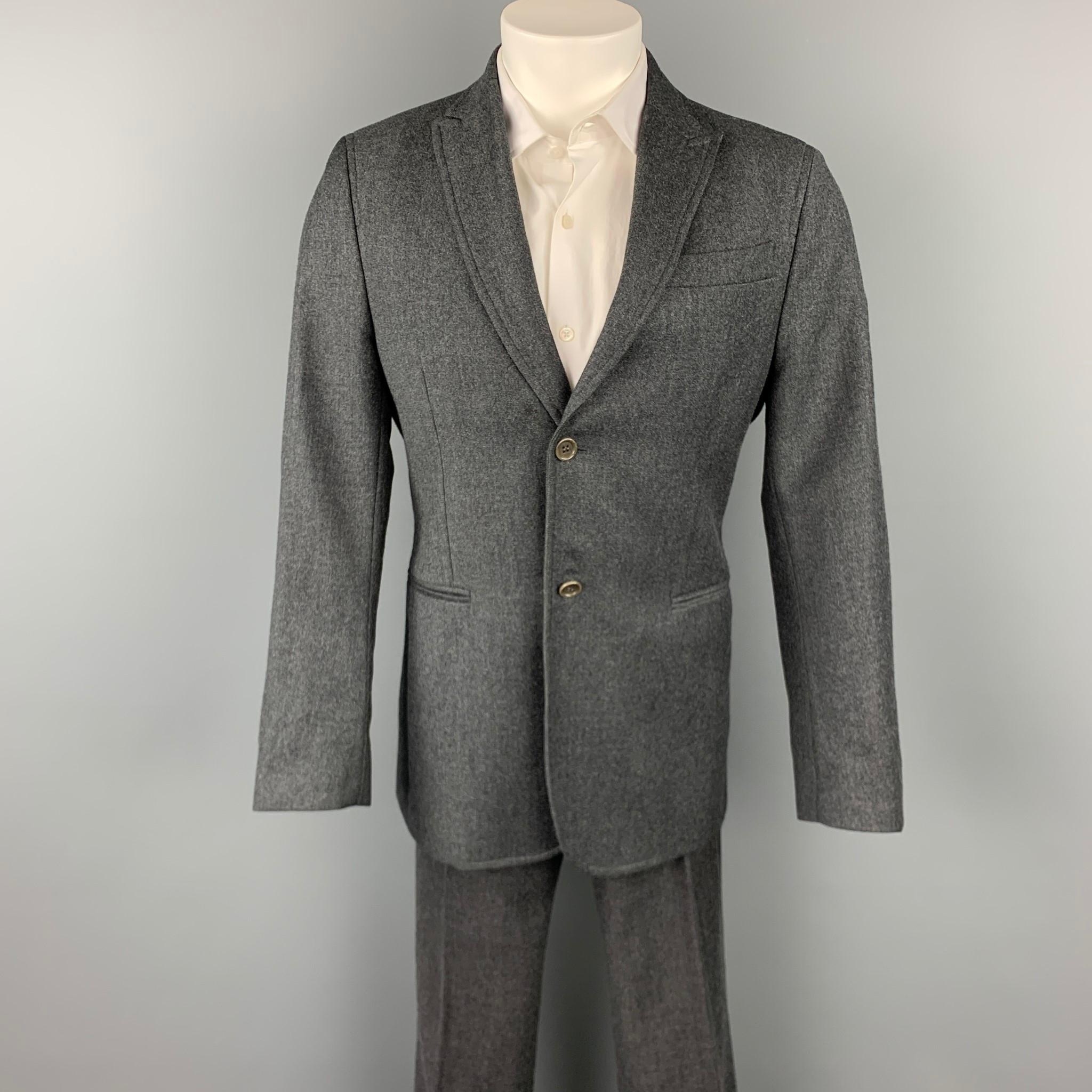 CoSTUME NATIONAL suit comes in a dark gray wool with a full liner and includes a single breasted, two button sport coat with a peak lapel and matching flat front trousers. Made in Italy. 

Very Good Pre-Owned Condition.
Marked: IT