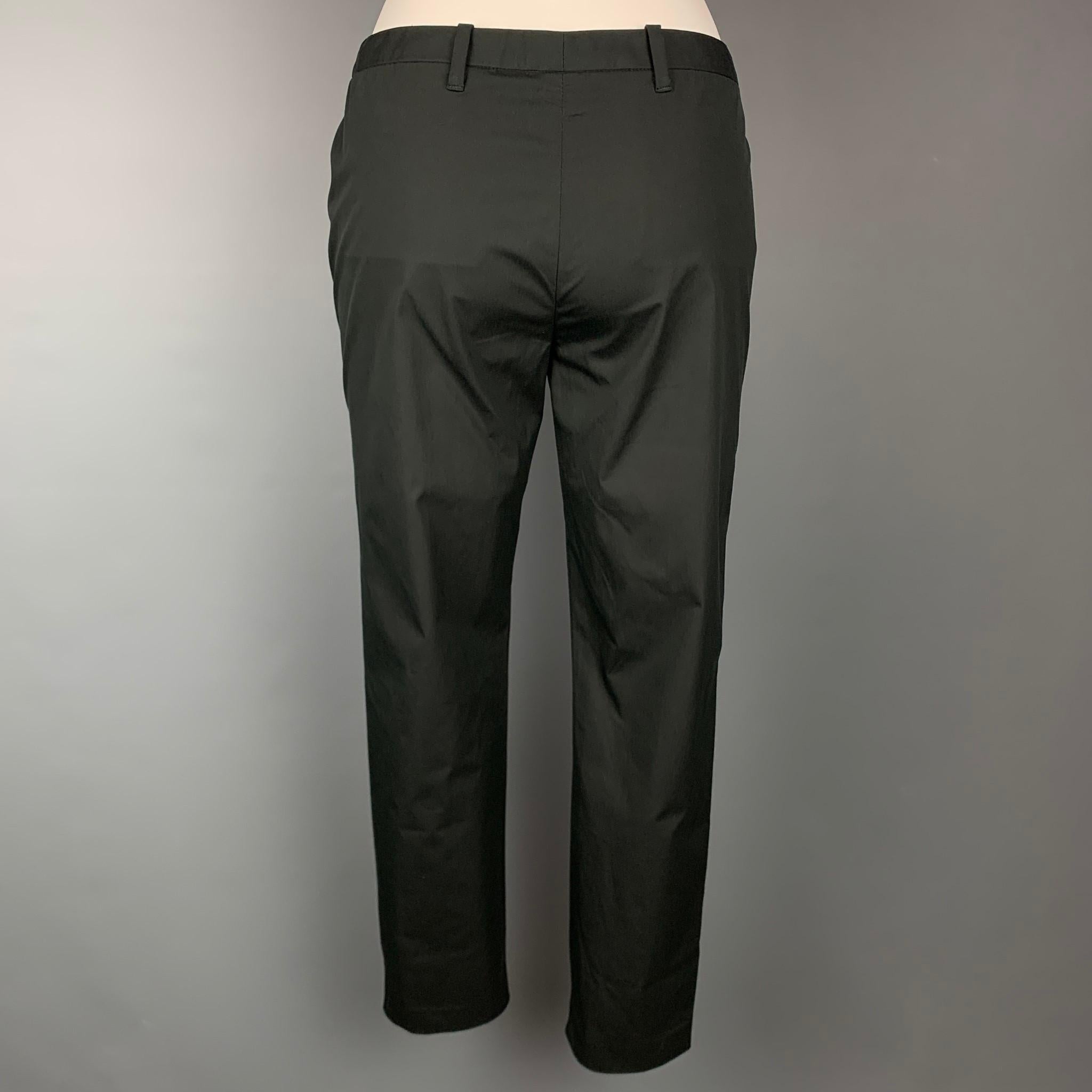 CoSTUME NATIONAL dress pants comes in a black cotton blend featuring a narrow leg, slit pockets, front tab, and a zip fly closure. Made in Italy.

Very Good Pre-Owned Condition.
Marked: IT 40

Measurements:

Waist: 29 in.
Rise: 8.5 in.
Inseam: 28