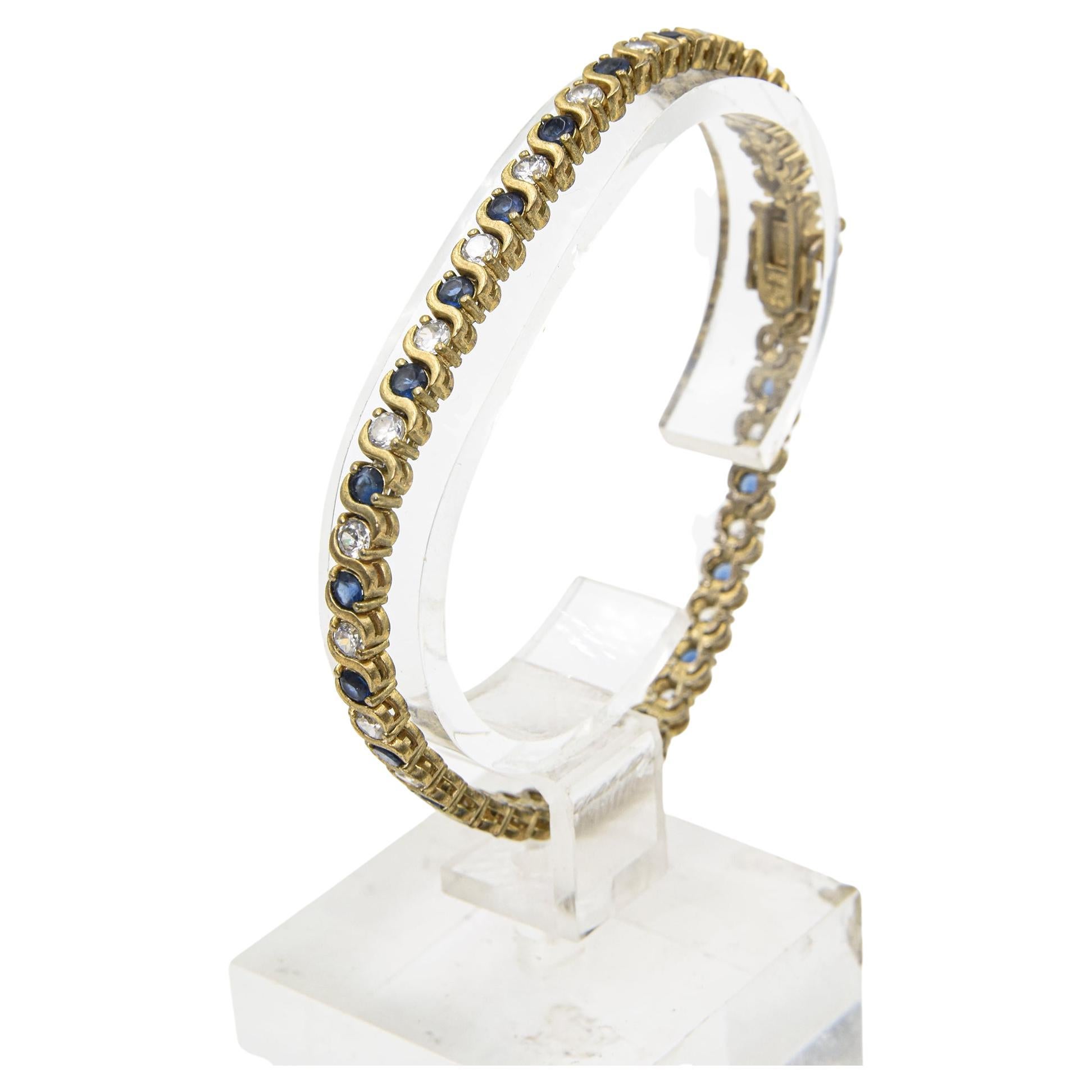 Faux sapphires and diamond bracelet made with crystal stones.  It combines classic tennis bracelet style with a colorful blue hue alternating with round-brilliant cut blue and clear crystals.  The stones are set in a gold plated sterling bracelet