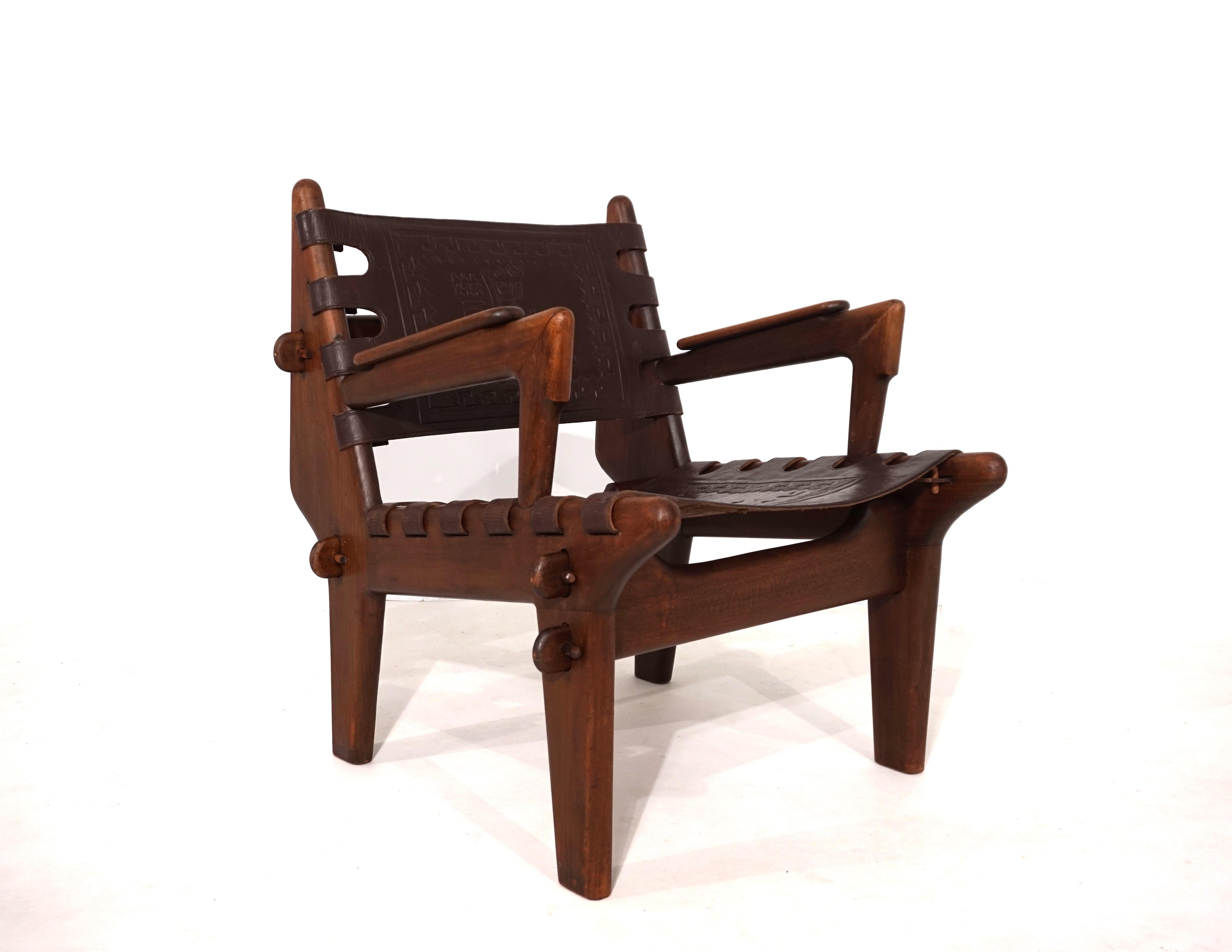 Fauteuil en cuir Condit d'Angel Pazmino en très bon état, avec cuir foncé et cadre en teck. Le siège en cuir épais est orné d'un motif inca en relief. Ces motifs varient sur presque tous les fauteuils. Le cadre est très robuste et, comme le cuir,