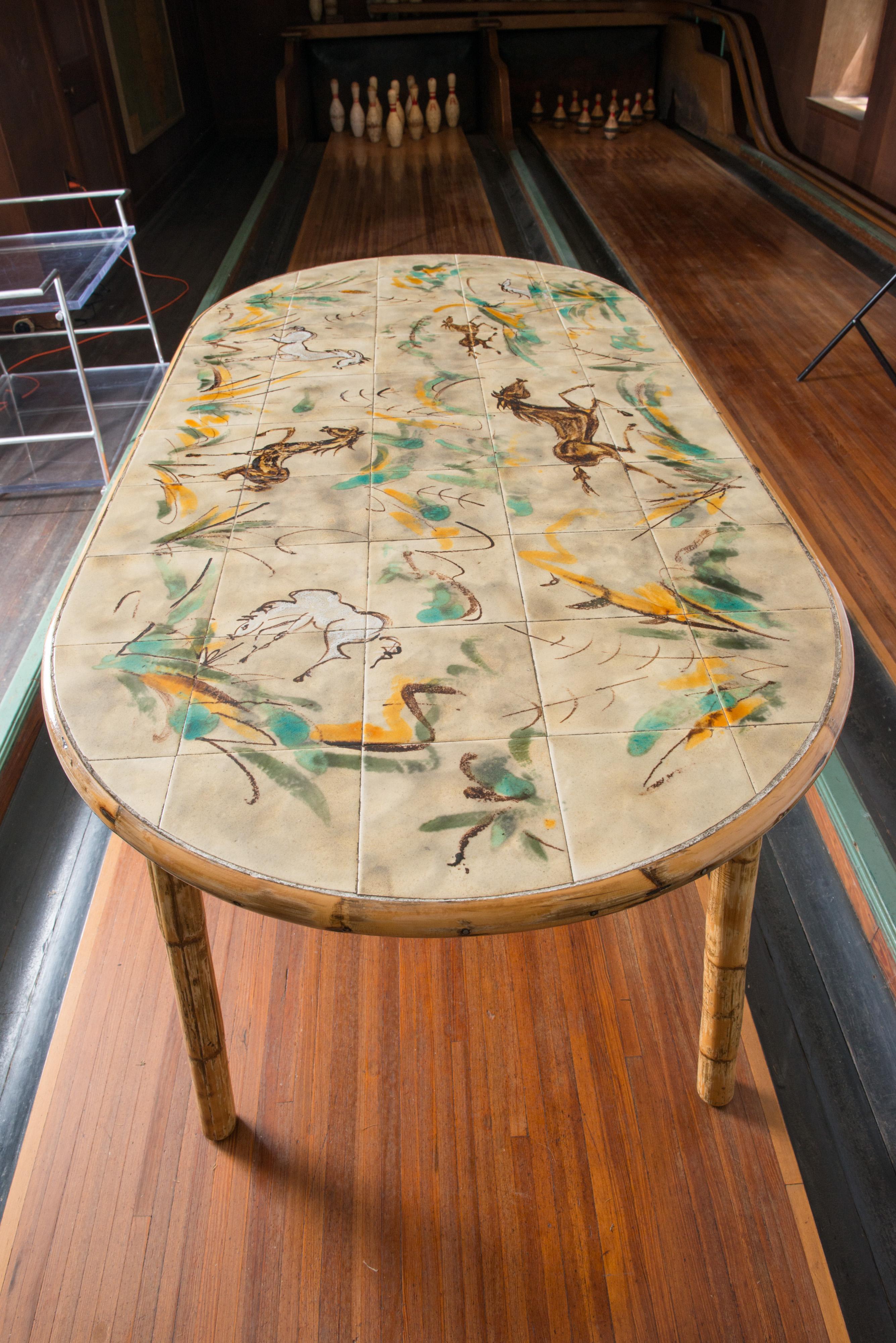 Spectacular 1960s Cote D'Azur signed oval ceramic top rattan table and four rattan chairs by Adrien Audoux and Frida Minet. Modern depiction of horses and grasses ceramic tiles signed by renown artist Georges Chassin. The four rattan chairs are in