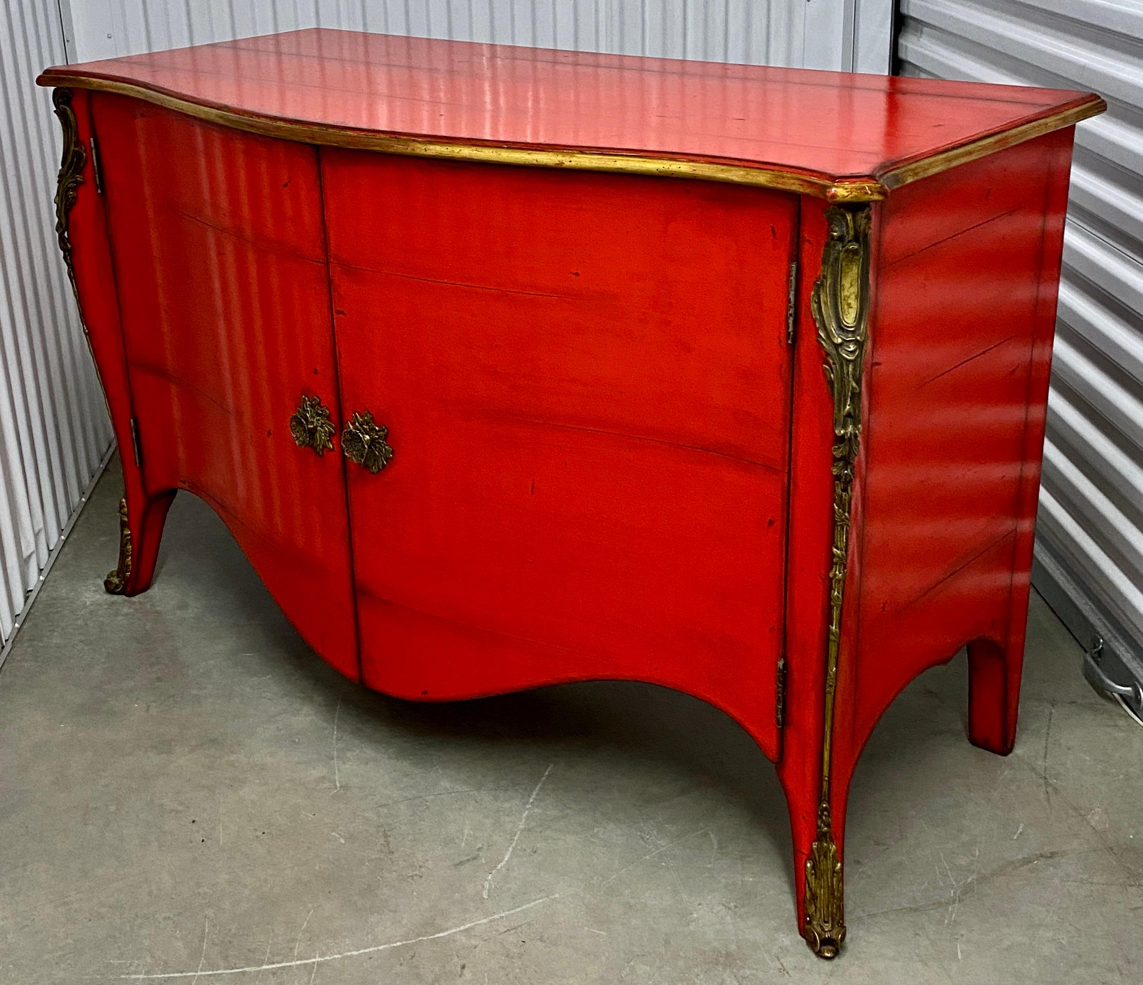 Made in France with fine quality craftsmanship, this modern take on antique design has great impact and style. This example has a striking red finish, gold details and a pistachio interior. Single shelf. Custom hardware is solid brass. Signature on