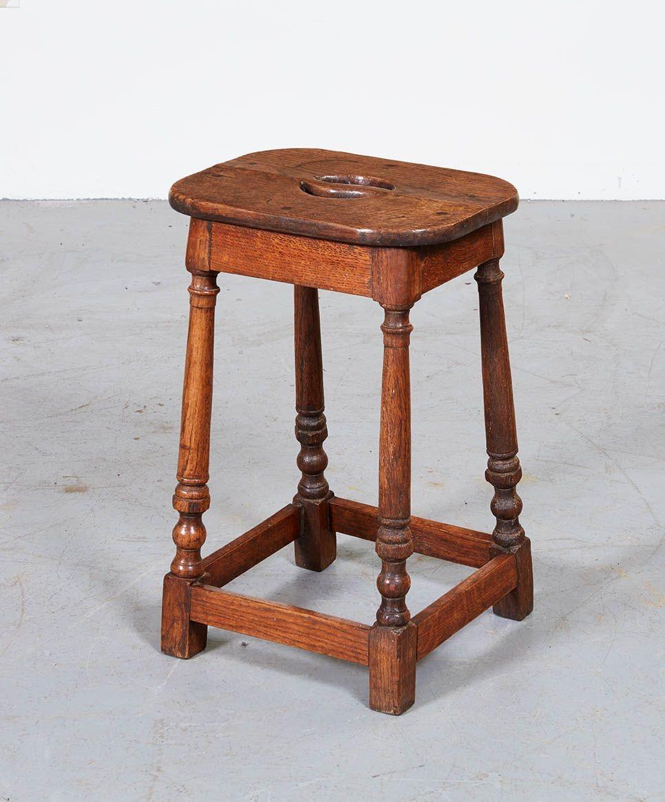 English Cotswolds School stretcher base oak tall stool with eased rectangular top having yin and yang hand-slot to top surface, on four turned and splayed legs joined by box stretcher. In the manner of Ernest Gimson.