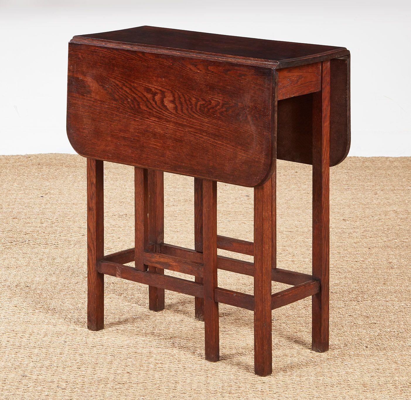A small Cotswold School drop leaf gateleg table in oak, the top with eased corners over an architectural vertical and horizontal leg configuration including swing gates.  A narrow profile with leaves down and a useful size when open make this table