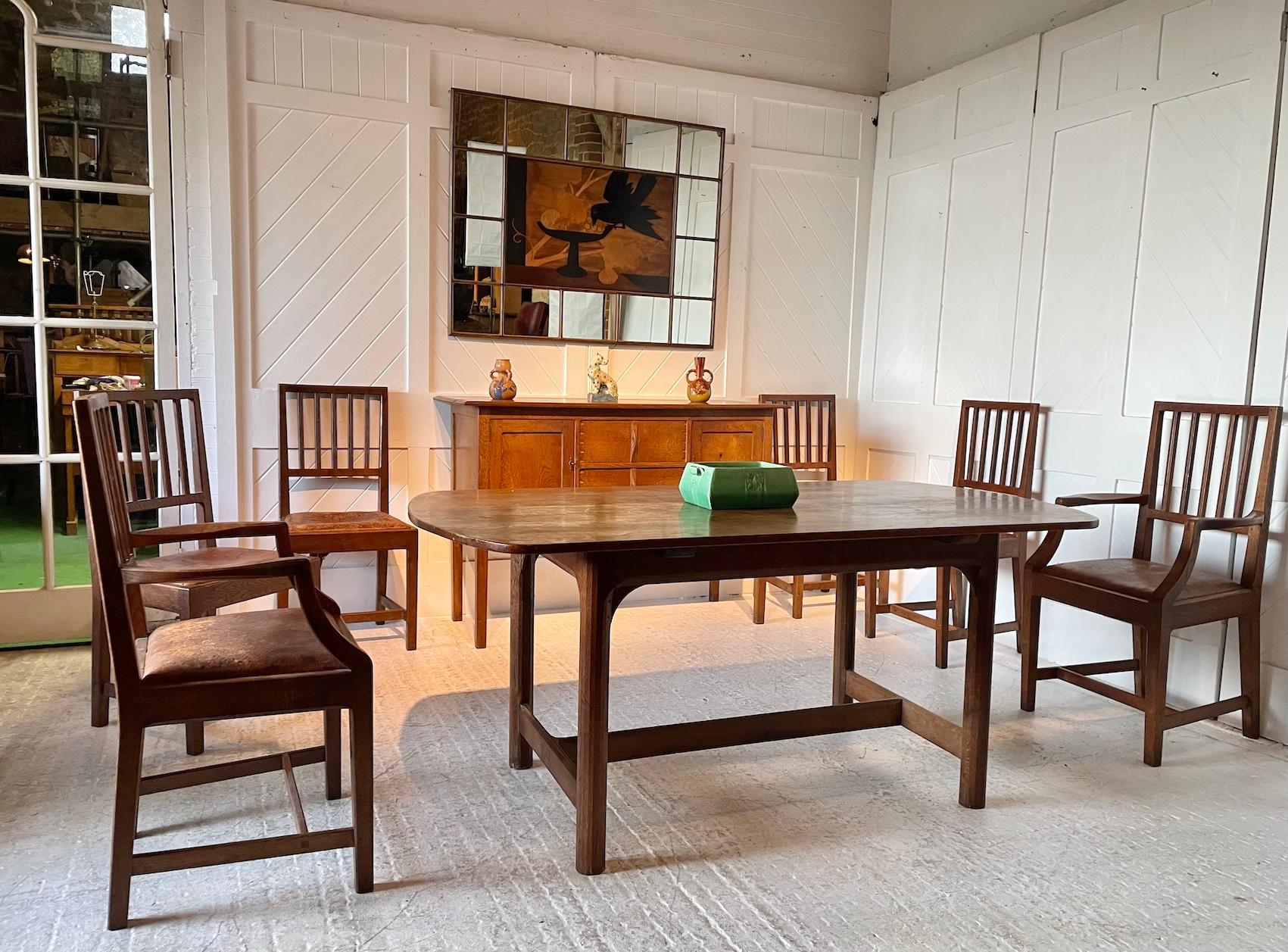 Cotswold School oak dining room suite

Six seater oak table has 4 faceted 12 sided legs joined by a chamfered ‘H’ stretcher with through wedge tenon joints and bespoke curved ended top.

The dining chairs with ribbed slats, chamfered rails with