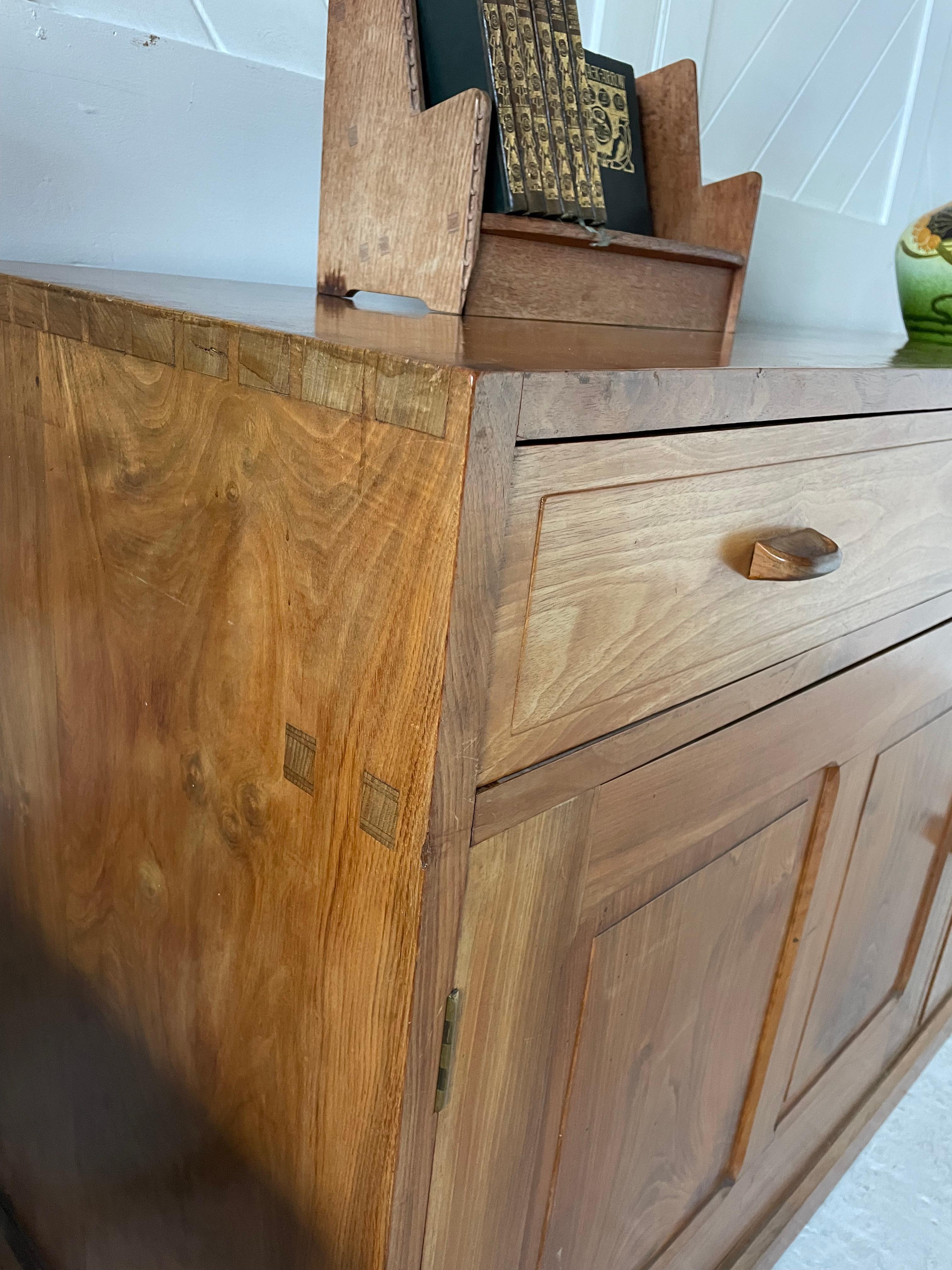 Credenza in noce a due cassetti e due ante della Cotswold School

Con code di rondine a vista

Ideato e realizzato da Fred Gardiner

Iscrizione incisa:  EP Gardiner.   Oakridge.    Stroud.   Glos.

CIrca 1950

Altezza 89 cm Larghezza 157,5 cm.