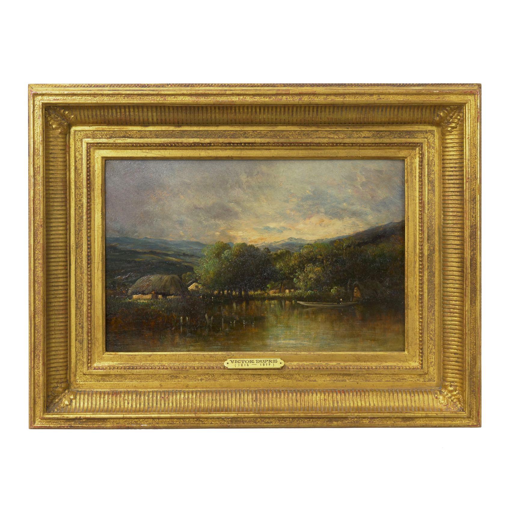 This exquisite little Barbizon painting captures a tranquil hamlet of thatched cottages lining a small body of water where a boater docks in the shallows. The sky is ominous and gloomy, suggestive of weather moving in on the valley as the clouds