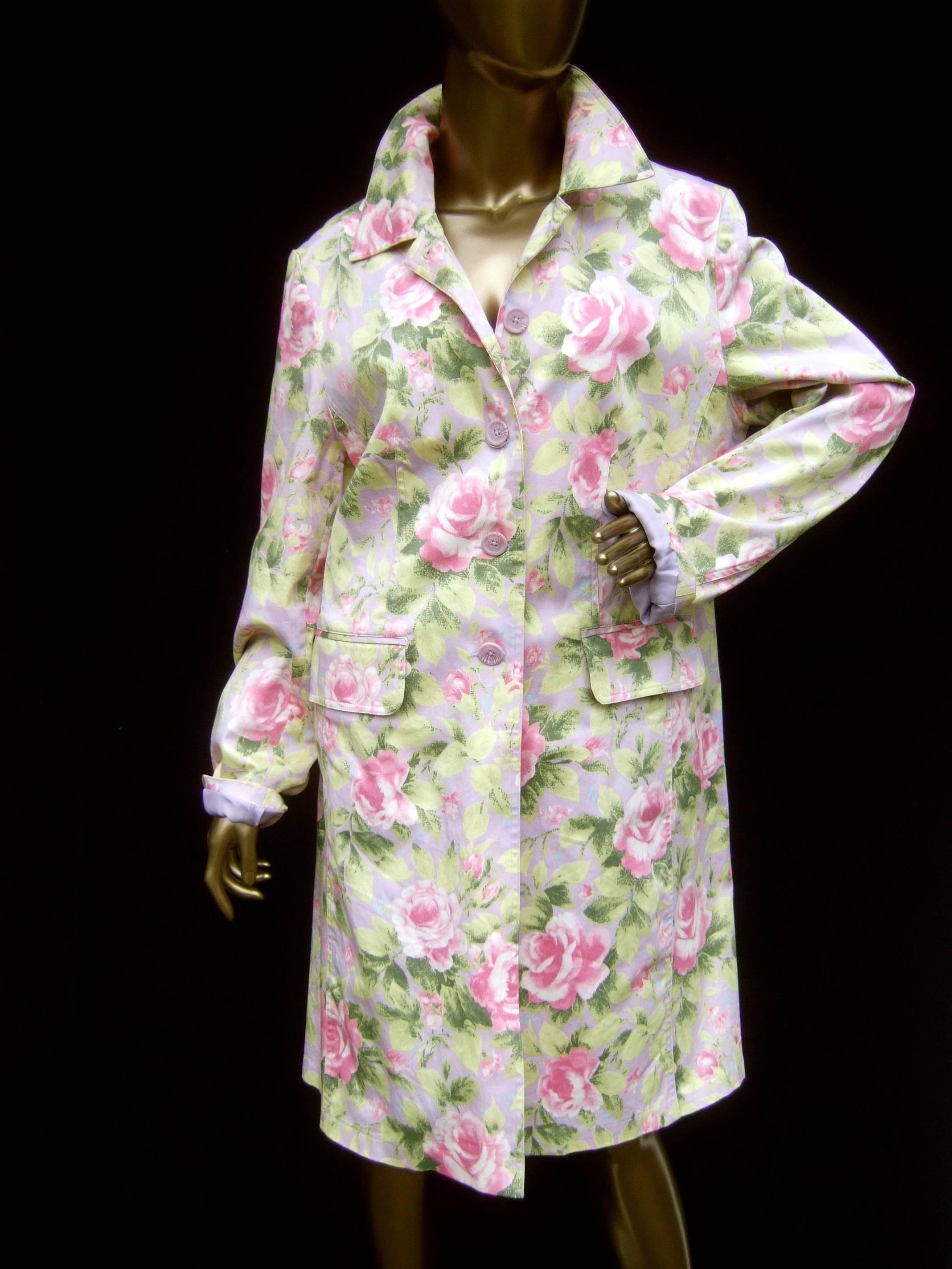 Cotton pastel rose garden floral print coat c 1990s
The spring time cotton coat is illustrated with 
billowy pale pink roses set against a muted 
lavender background 

The light weight floral coat has a set of lavender
lucite buttons that partially