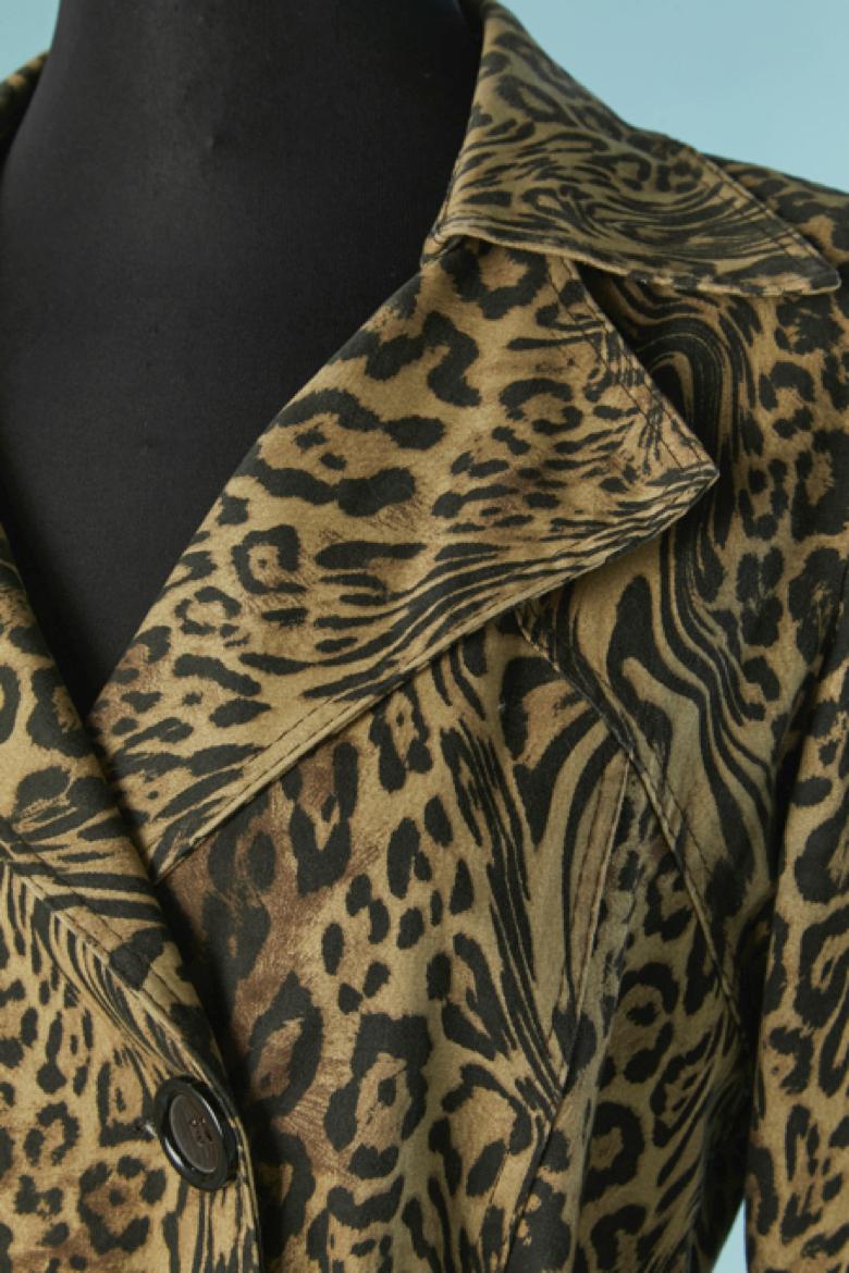 Gabardina de algodón con estampado animal. Composición del tejido principal: 98% algodón, 2% elastán. Forro de rayón o acetato. 
Hombrera. Cinturón con hebilla y trabilla. Bolsillo en ambos lados. Botón y ojal en la parte delantera y en los