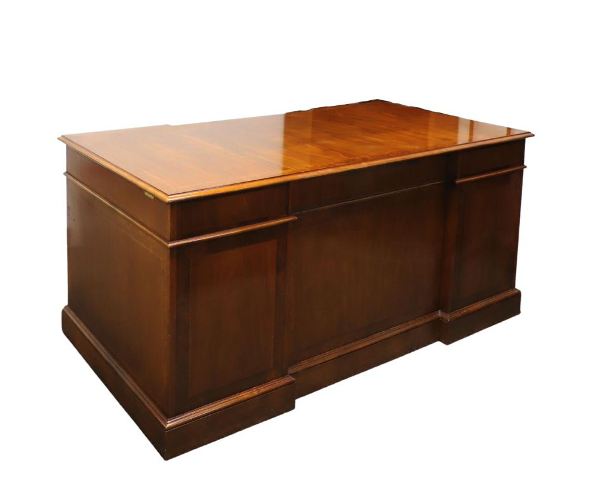 A Traditional style double pedestal executive desk by Councill Business Furniture. Walnut and burl walnut, banded top, brass hardware, banded drawer fronts & panels, and solid pedestal bases. The user side of the desk features seven drawers of