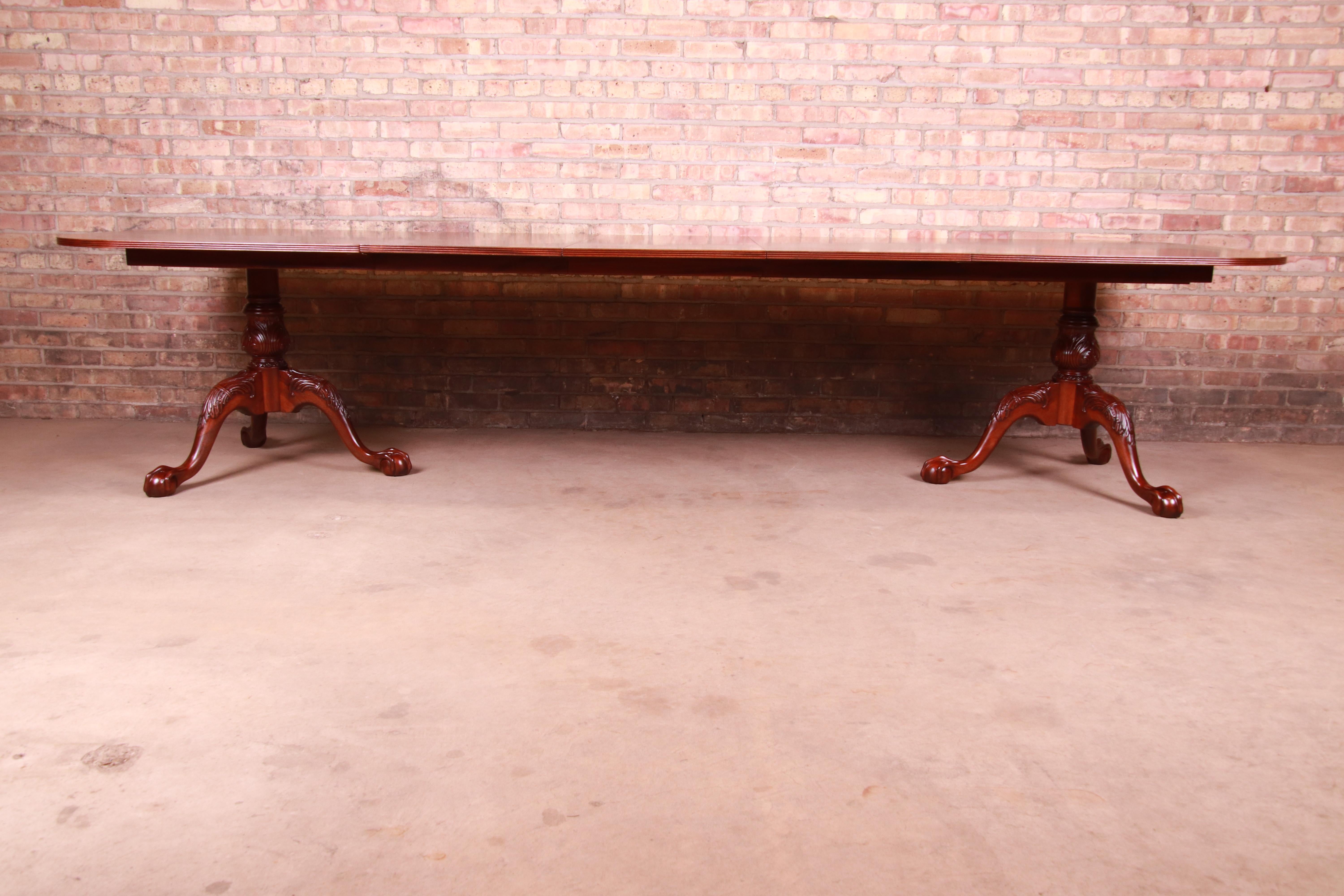 An exceptional Chippendale style double pedestal extension dining table

By Councill Furniture

USA, circa 1980s

Book-matched mahogany, with inlaid satinwood banding and carved solid mahogany pedestals with ball and claw feet.

Measures: