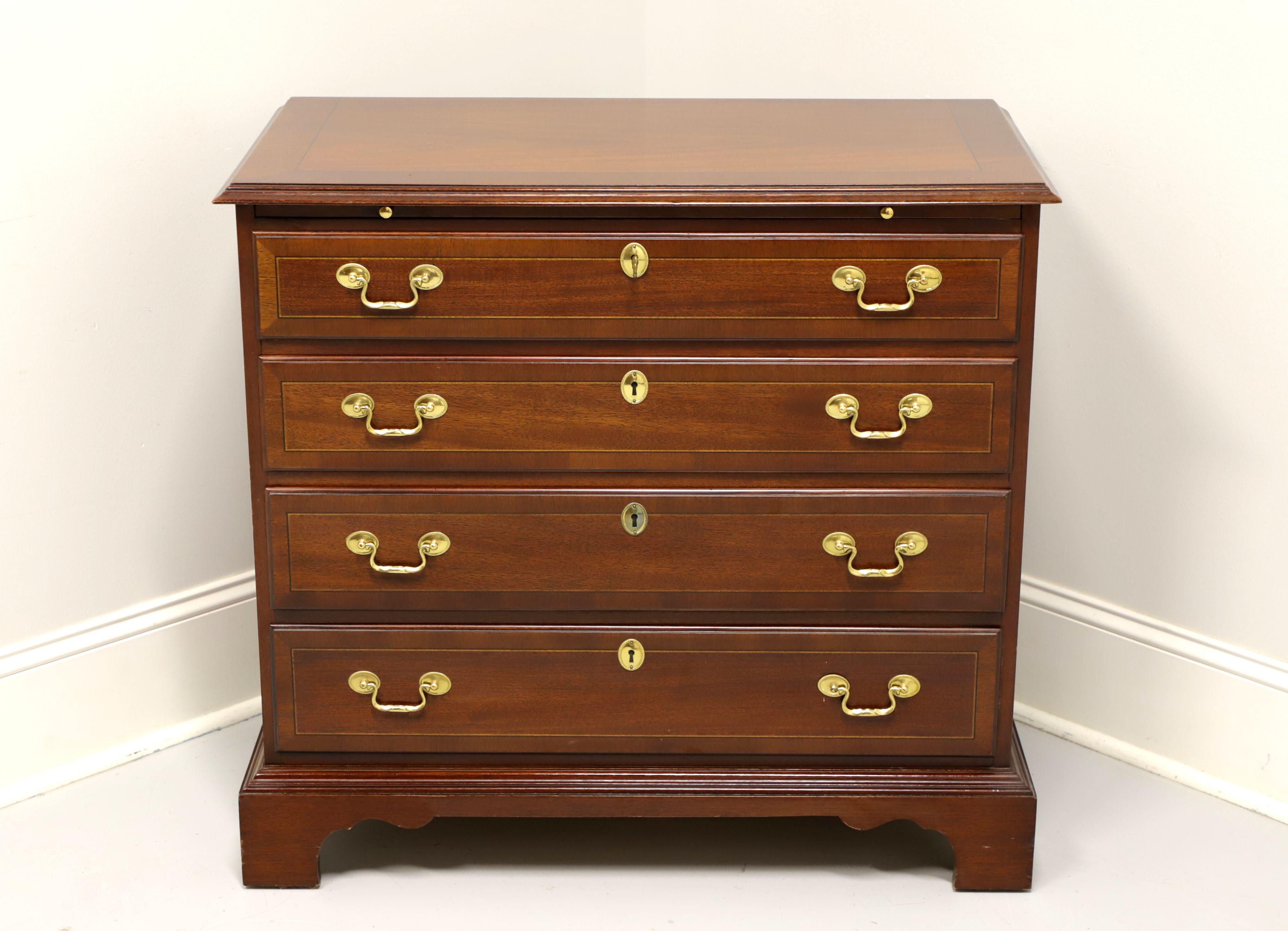 A Chippendale style bachelor chest by Councill Craftsmen. Mahogany with banded mahogany top & drawer fronts, brass hardware and bracket feet. Features a brushing slide and four drawers of dovetail construction, top drawer being lockable. Includes