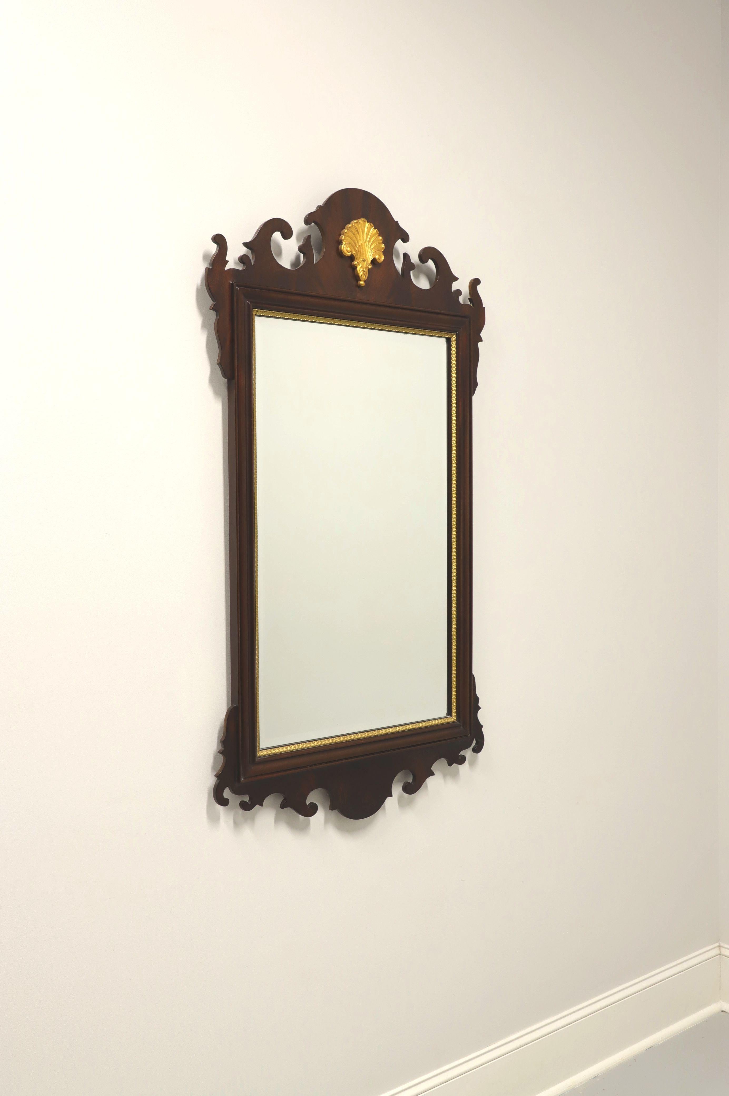 A large Chippendale style wall mirror by Councill Craftsmen. Bevel edge mirrored glass, mahogany frame with gold trim and top center gold plume. Made in Denton, North Carolina, USA, in the late 20th Century. 

Measures: 28.75w 1.5d 52h, Weighs