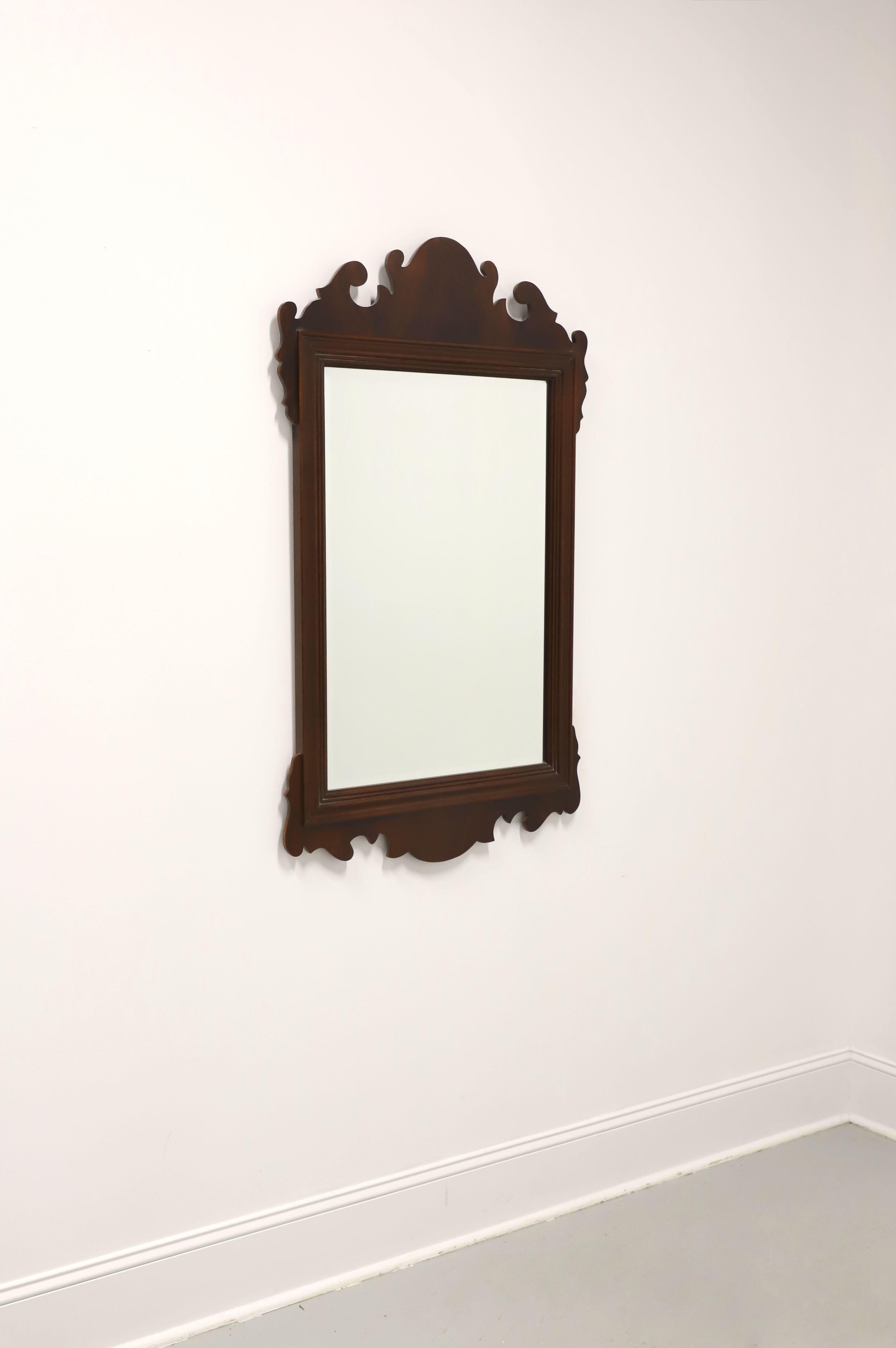 A large Chippendale style wall mirror by Councill Craftsmen. Bevel edge mirrored glass in a mahogany frame with fluted edges and decoratively carved at top & bottom. Made in Denton, North Carolina, USA, in the late 20th Century. 

Measures:  29w
