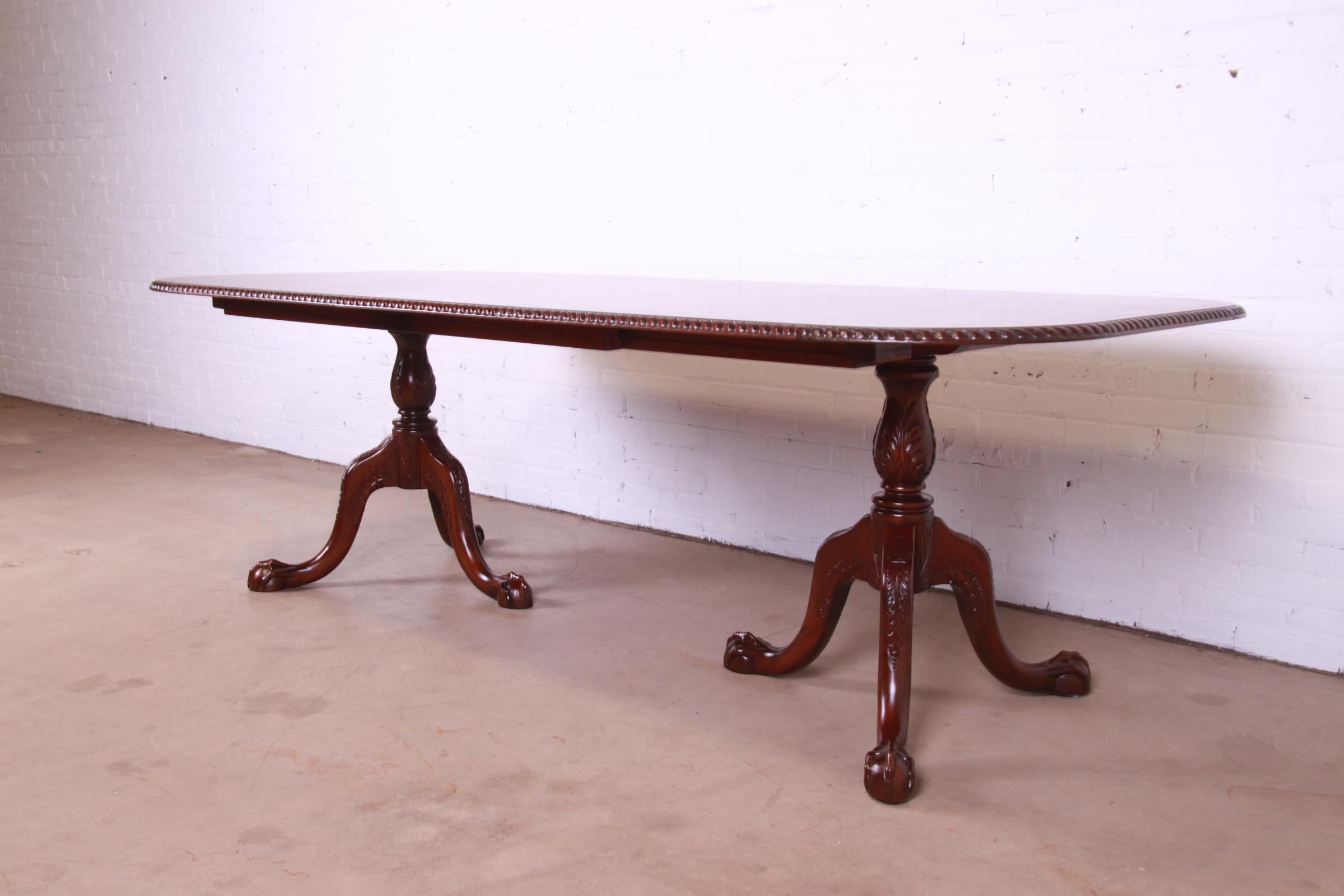 A gorgeous Chippendale or Georgian style double pedestal carved mahogany extension dining table

By Councill Furniture

USA, Circa 1980s

Measures: 76.25