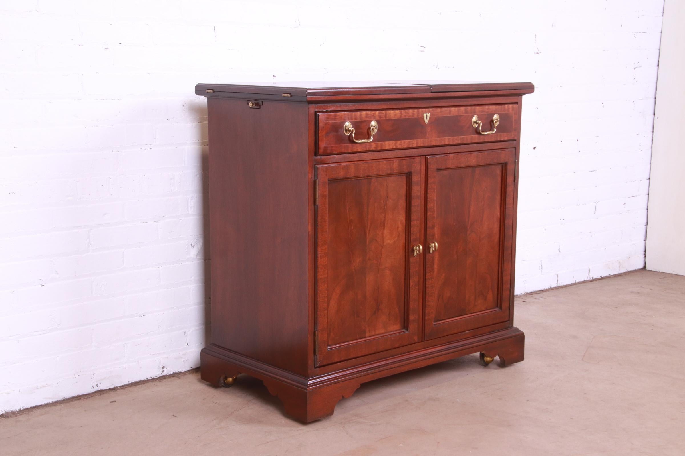 20th Century Councill Furniture Georgian Banded Flame Mahogany Flip Top Rolling Bar Cabinet