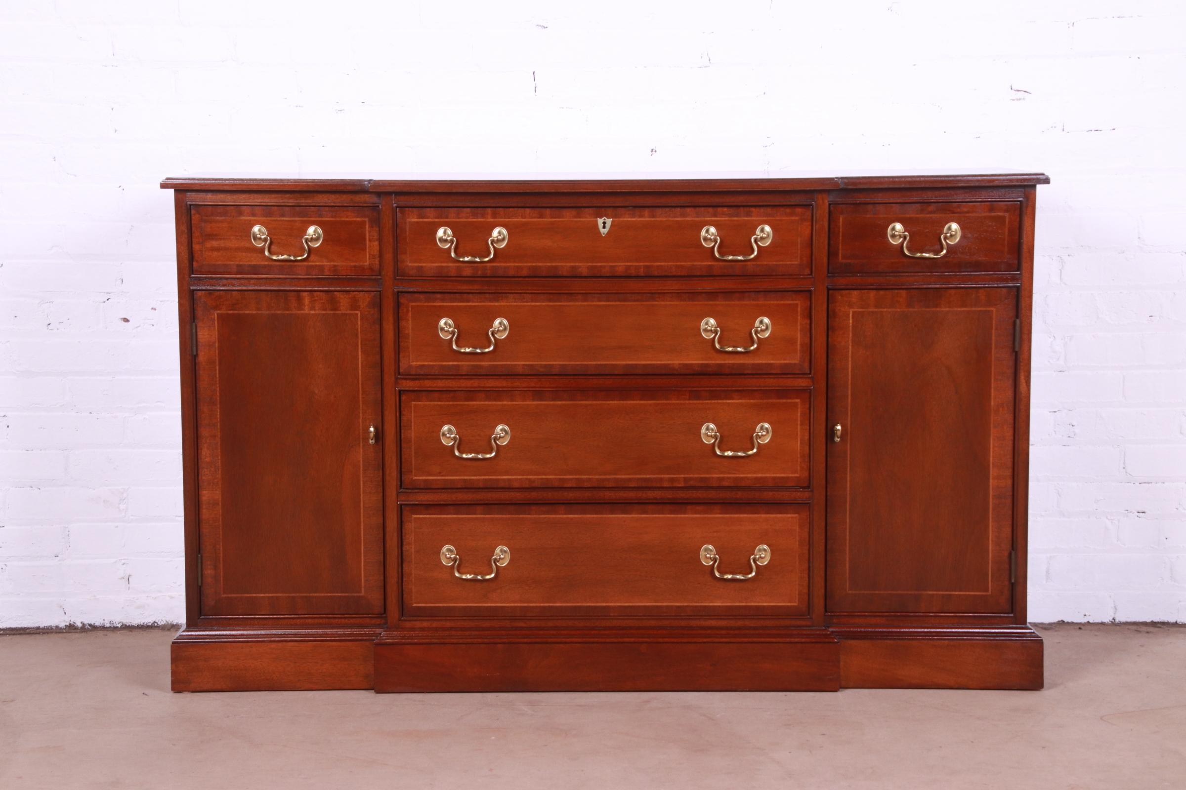An exceptional Georgian or Chippendale style breakfront sideboard, credenza, or bar cabinet

By Councill Furniture

USA, Circa 1980s

Banded mahogany, with satinwood inlay and original brass hardware.

Measures: 55.75