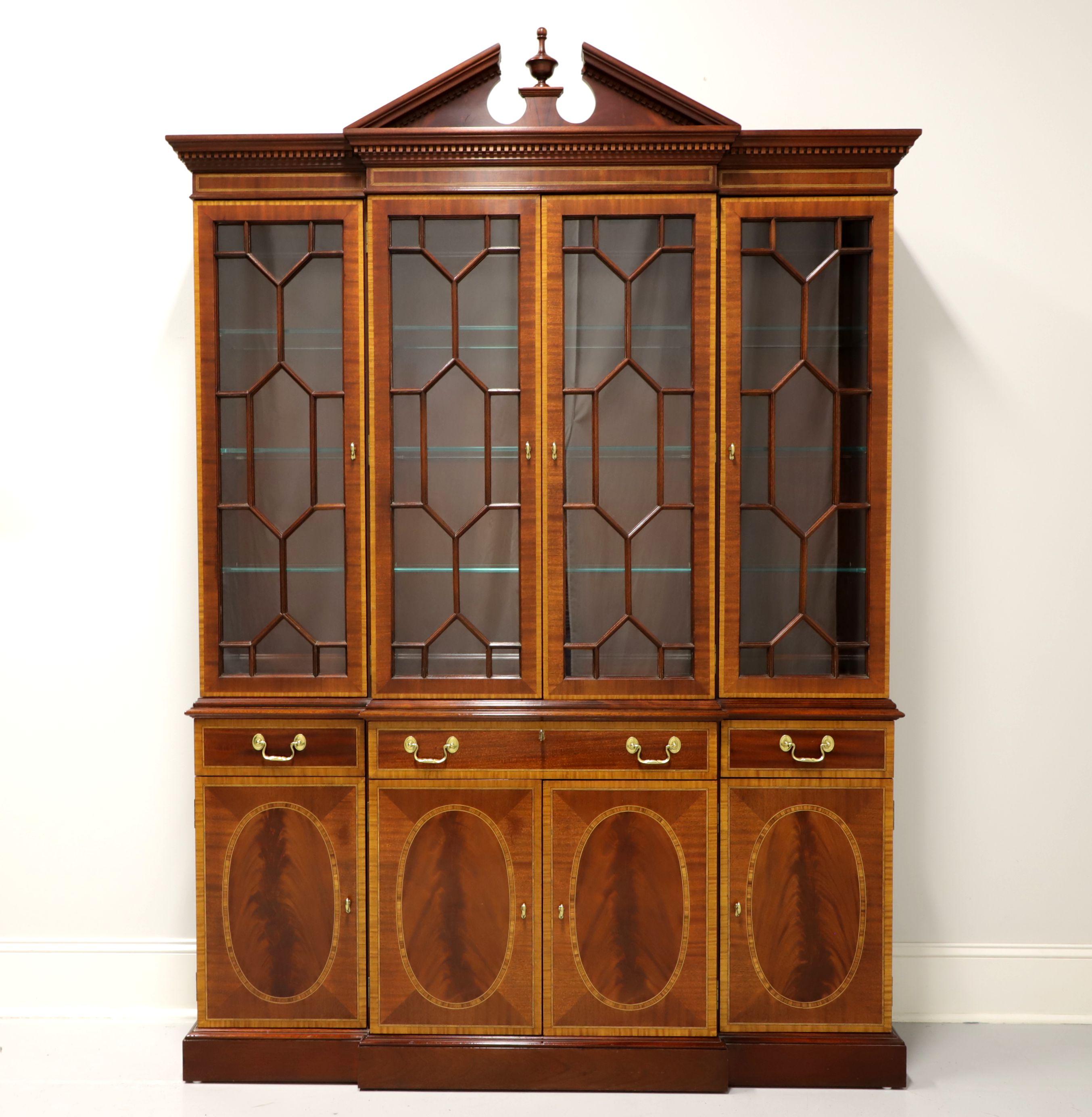A breakfront china cabinet in the Hepplewhite style by Councill Craftsmen. Inlaid flame mahogany with brass hardware, pediment with finial & dentil moulding to top of cabinet and inlaid oval door fronts to lower cabinet. Upper lighted cabinet