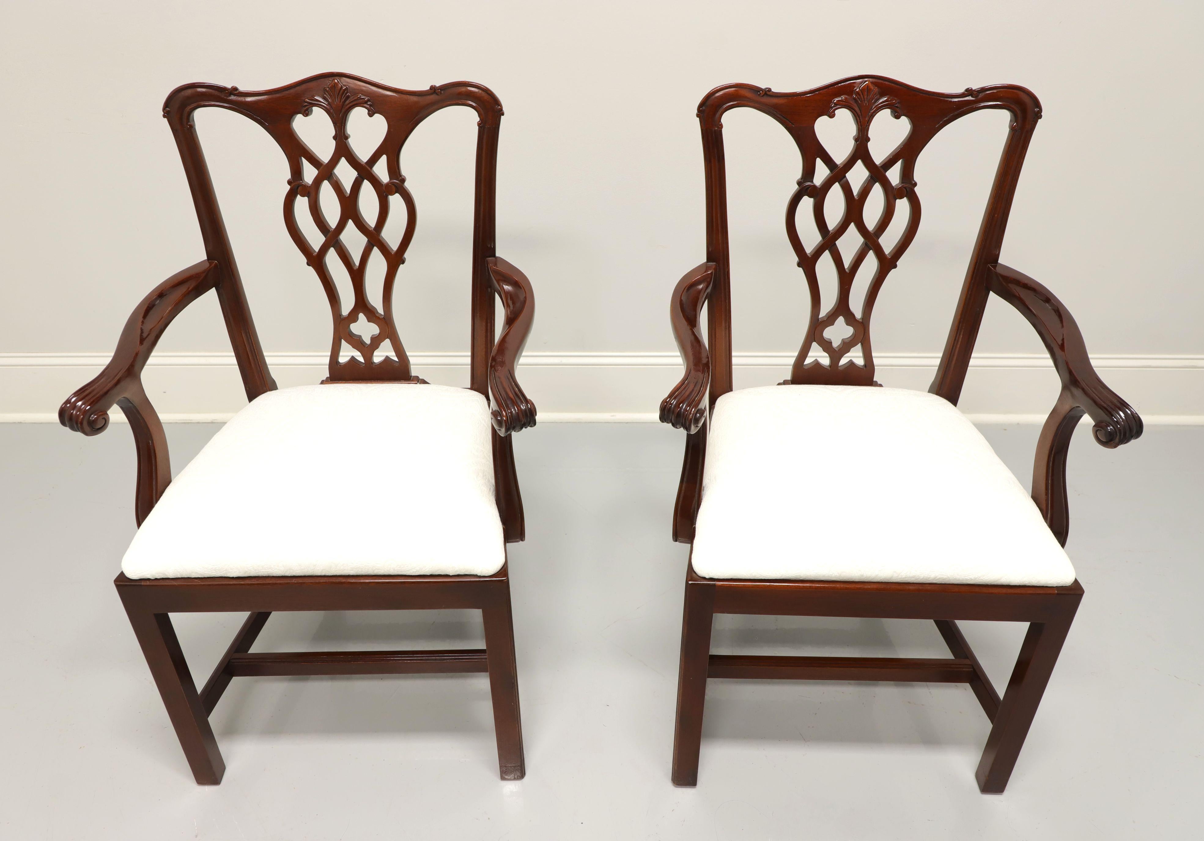 A pair of Chippendale style dining armchairs by Councill. Solid mahogany with carved crest rail, backsplat, scroll arms, straight legs and stretchers. Seats upholstered in a neutral cream colored brocade fabric. Made in the USA, in the late 20th