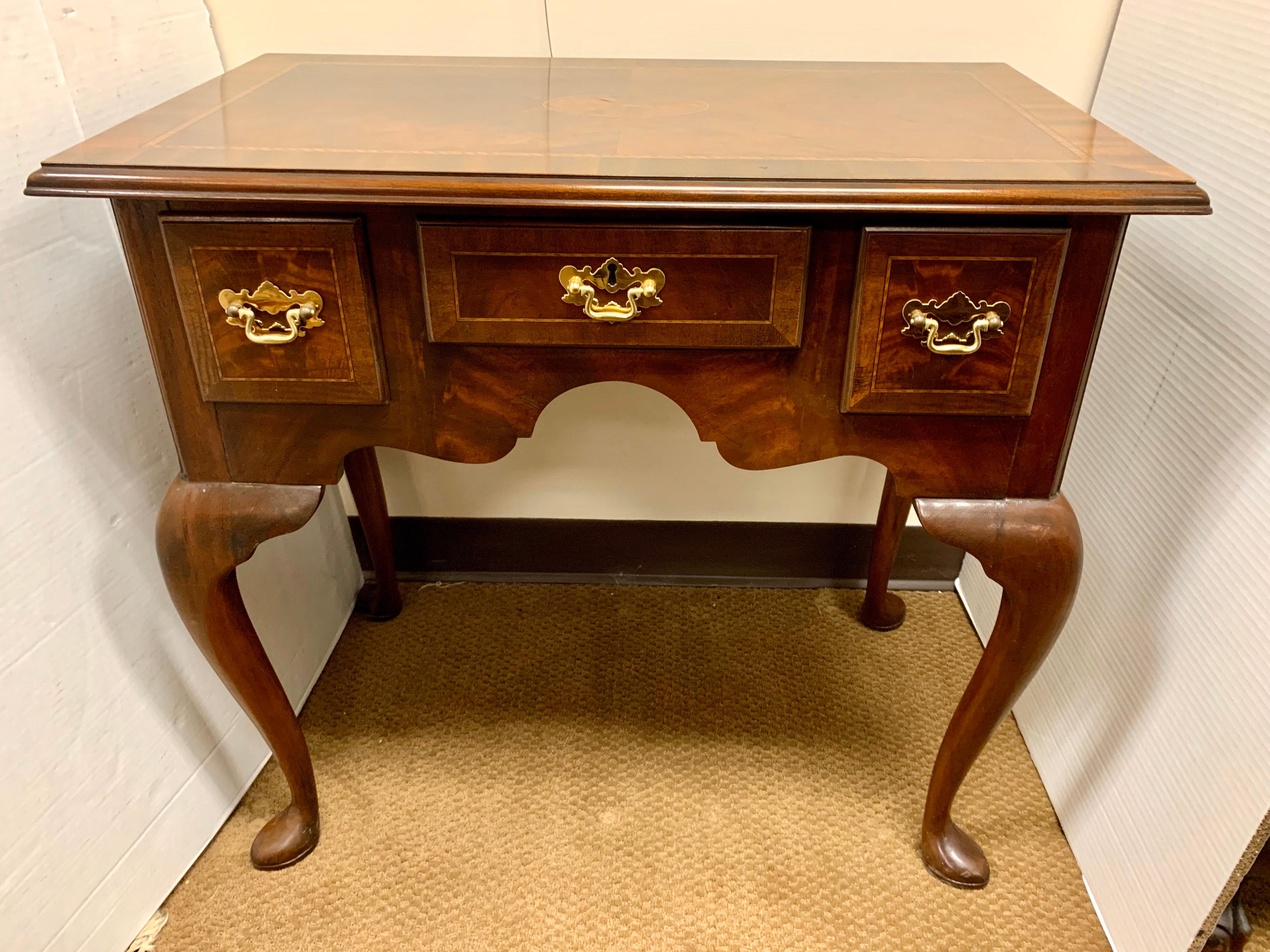 Councill Craftsman handcrafted Queen Anne style lowboy table with flame mahogany construction with three dovetailed drawers. Top has satinwood inlay with central patera and rope twist banding, raised on cabriole legs having spade feet, maker plate