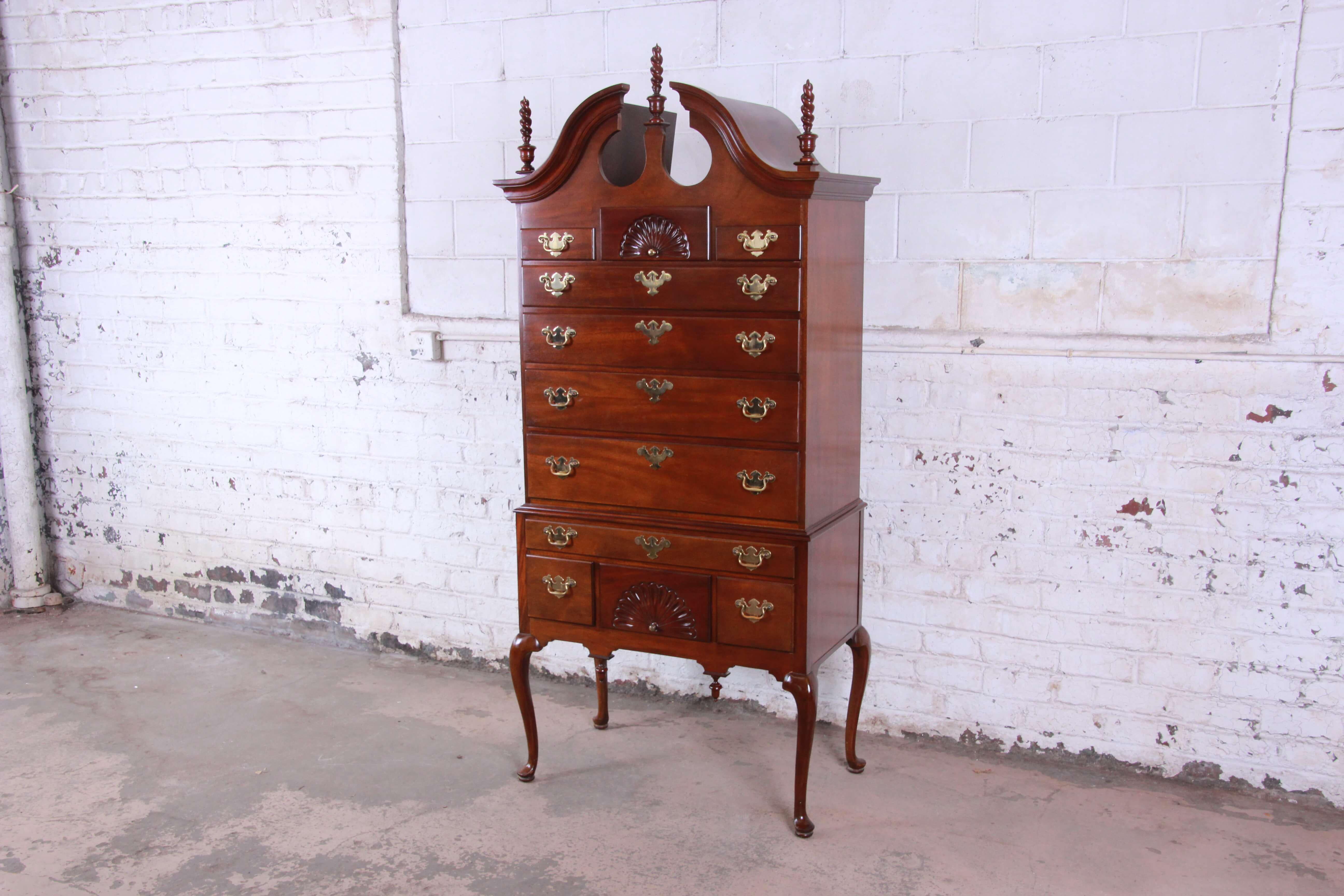 Offering a very nice vintage Queen Anne mahogany highboy dresser by Councill. The dresser is made from solid mahogany and features eleven smooth sliding drawers for lots of organization and storage options. The top has three spiral spindles and