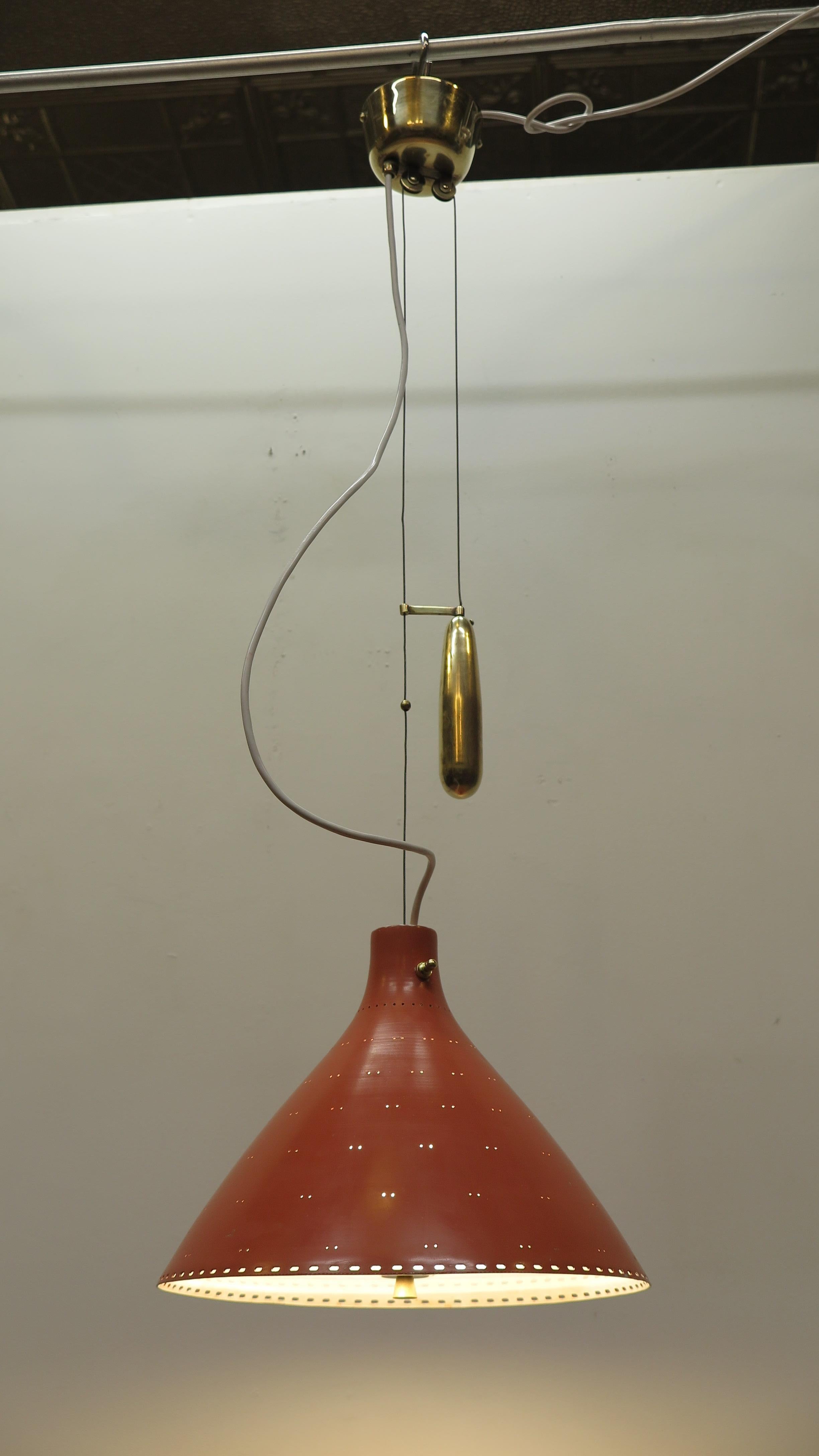 Paavo Tynell counter balance pendant lamp. Early counter balance pendant light by Paavo Tynell model A1942. Having brass canopy with two pulley wheels, wire receiver, stainless steel cable supporting Aluminum painted shade. Solid brass slide weight