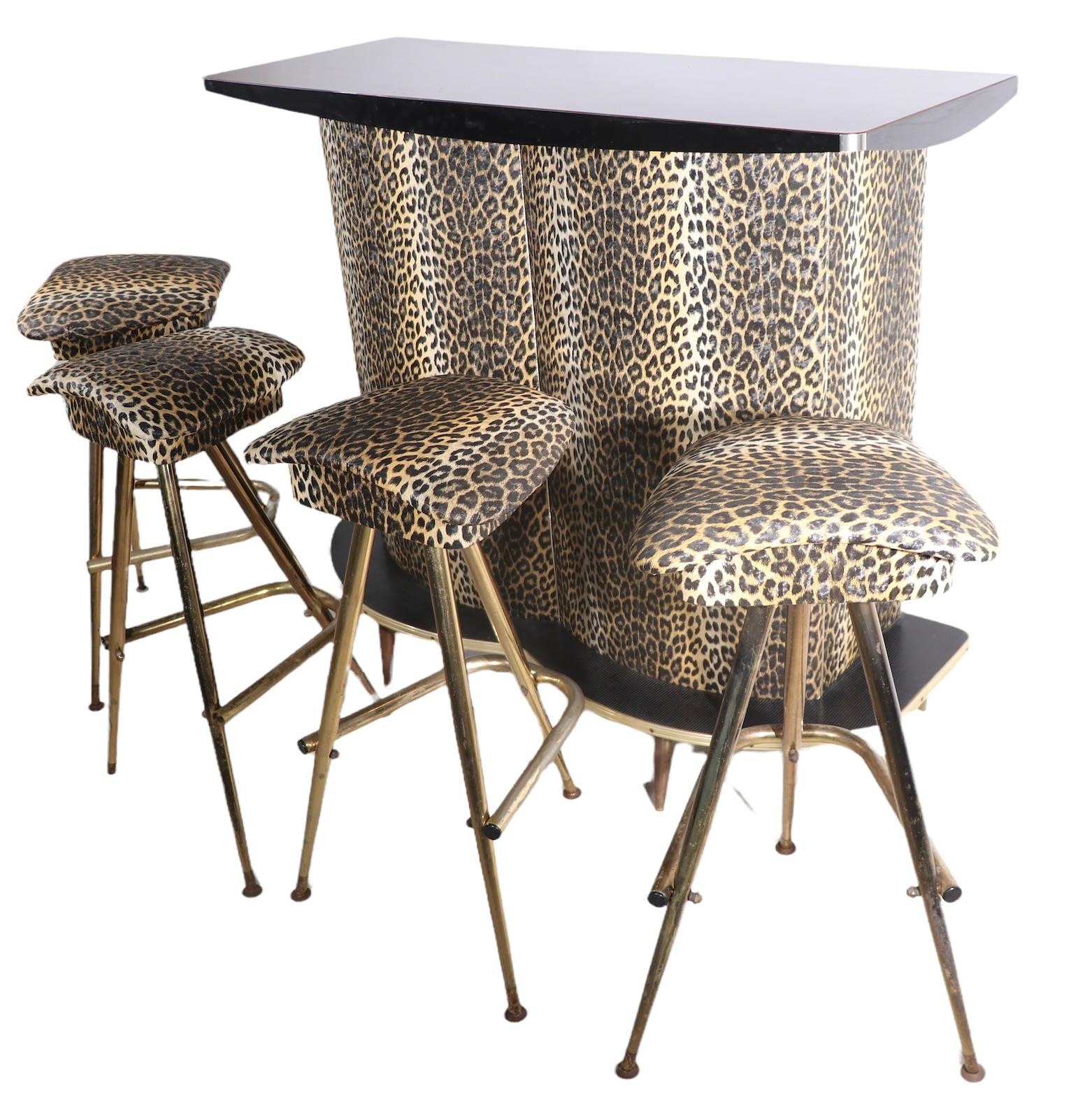 Way cool counter bar in cheetah vinyl and faux wood formica laminate, with 4 original matching stools. It doesn't get much funkier than this throw back set from back in the day. Structurally sound and sturdy, the metal finish on the bar stools shows