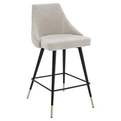 Tabouret de comptoir en tissu gris clair avec pieds en métal noir et finitions en laiton