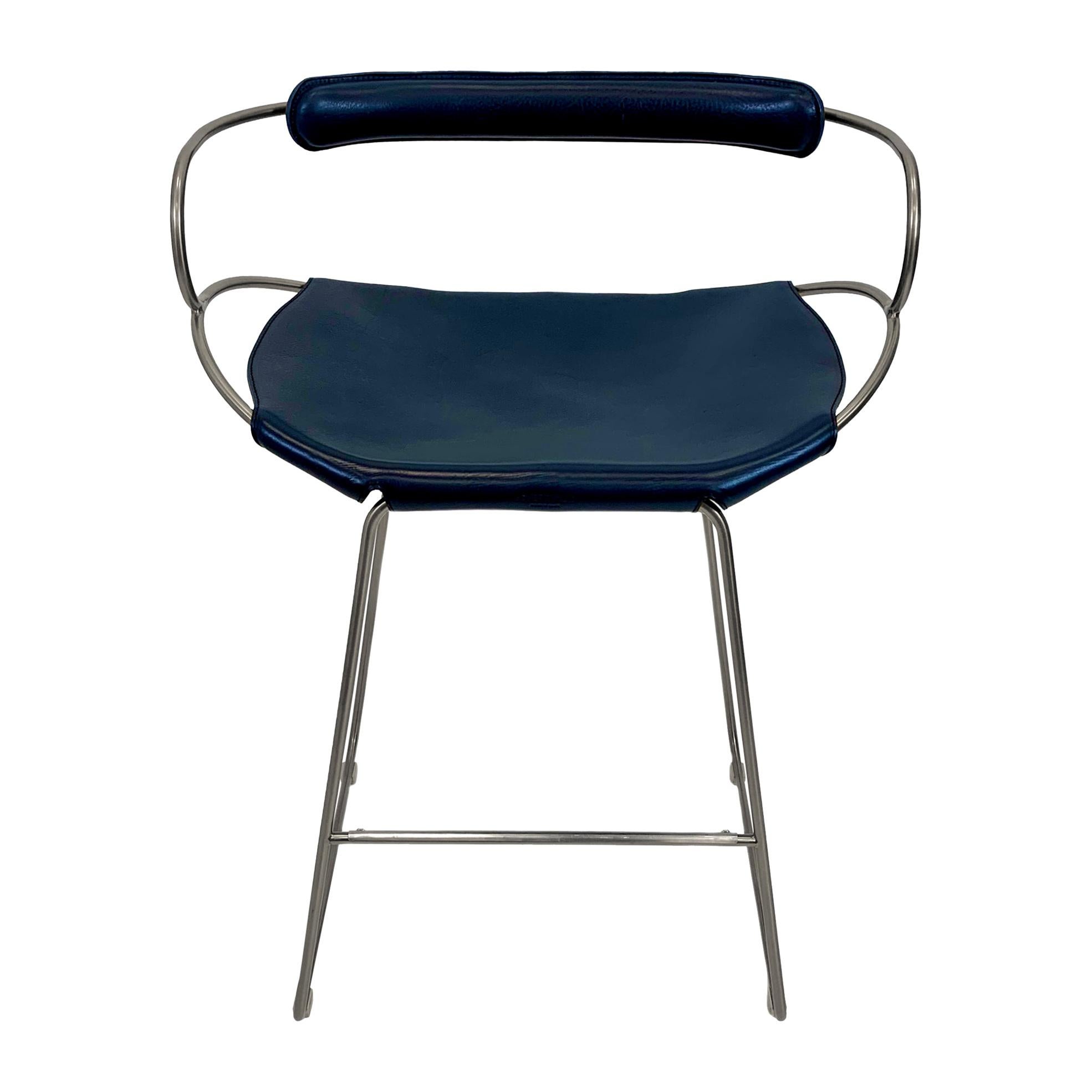 El taburete de mostrador contemporáneo con respaldo Hug está diseñado y concebido con una estética ligera, la ligera oscilación de la varilla de acero de 12 mm se complementa con la flexibilidad de la doble piel de 3,5 mm de grosor. Al sentarte en