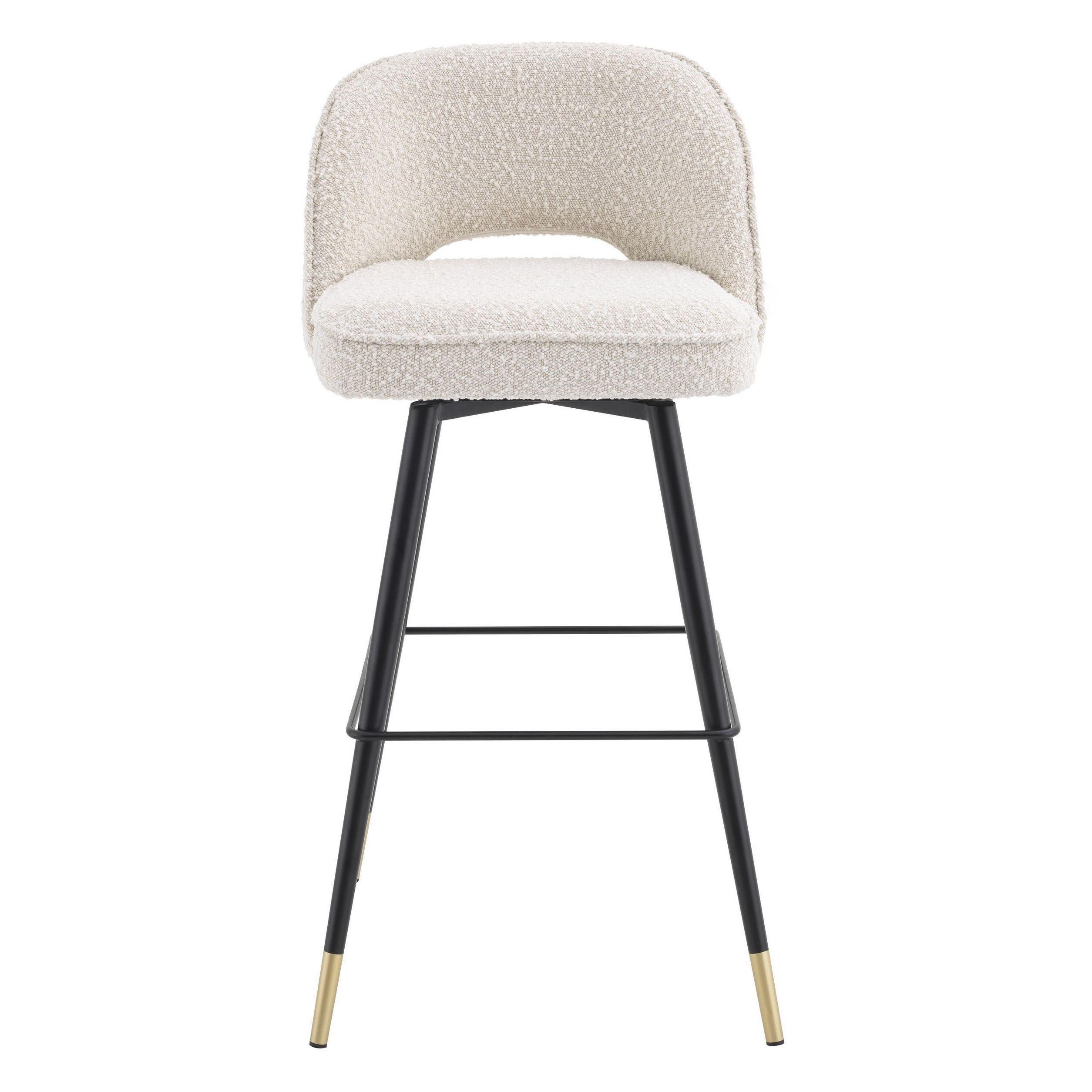 Counter swivel bar stool in bouclé fabric black metal feet and brass finishes.