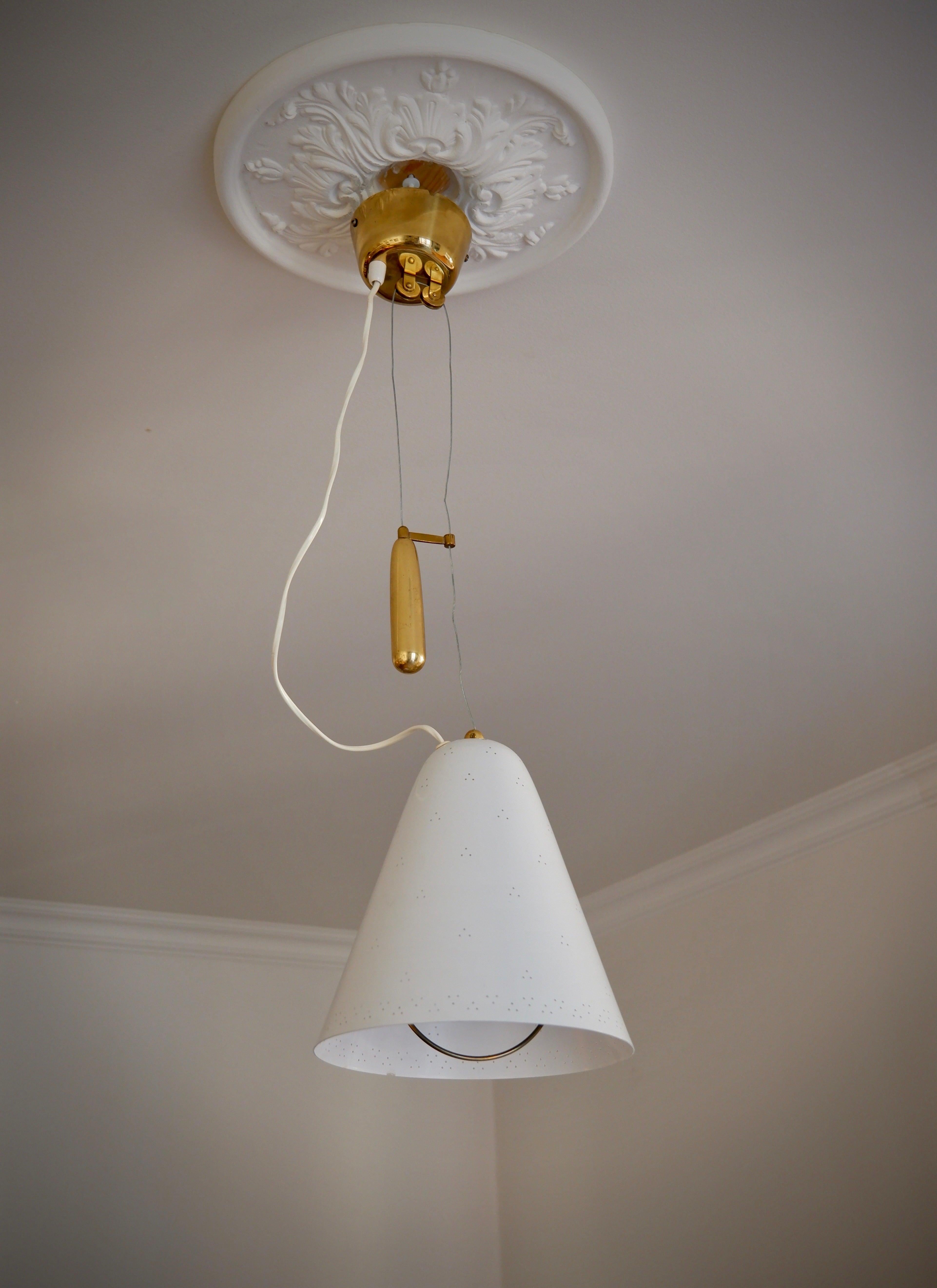 Important ceiling light designed by Paavo Tynell in the 40's and produced by Idman during the 50's. The lamp has a counter weight system to be able to increase or reduced the hight of the lamp. The lamp is in really good condition and it's stamp by