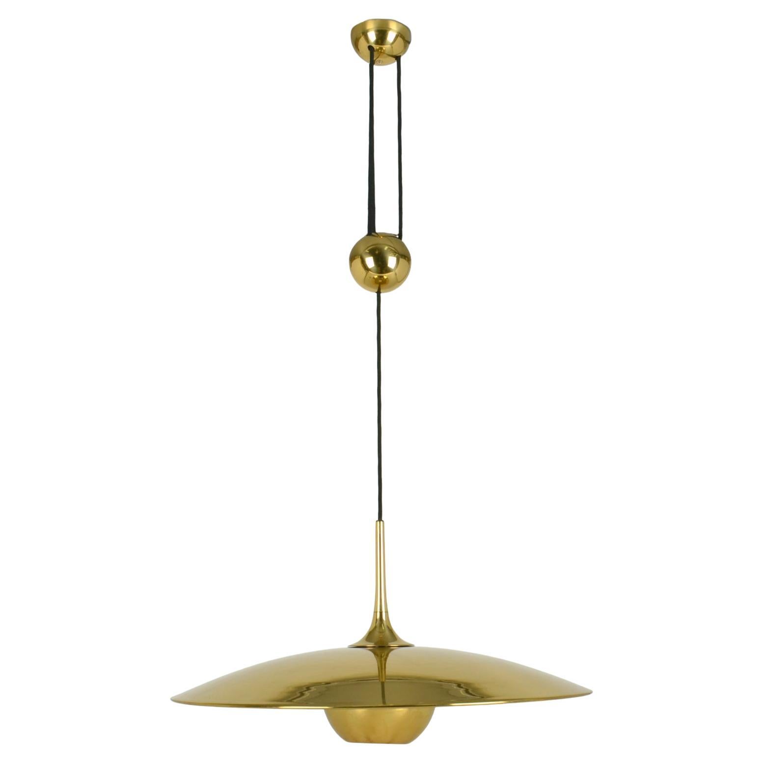 Original counterbalance pendant Onos 55 by Florian Schulz. This elegant and minimal pendant in a high quality polished brass, moves smoothly up and down due to the solid brass center counterweight. The shade has a brass diffuser. 
Excellent