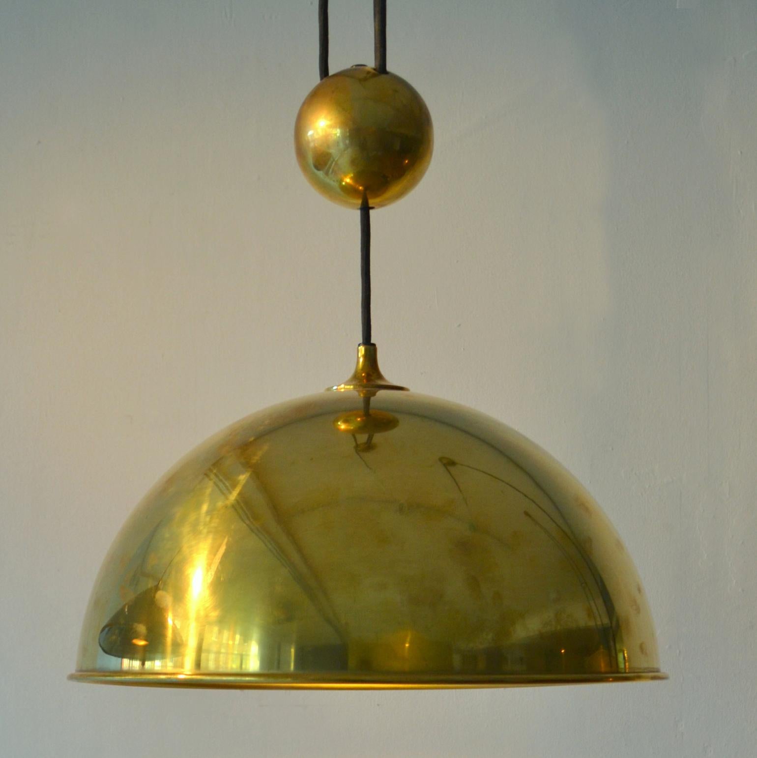 Original counterbalance pendant 'Posa' by Florian Schulz with centre weight. Strong and minimal pendant in a high quality spun brass moves smoothly up and down due to the solid brass counterweight. The brass is coated. 
Excellent timeless design of