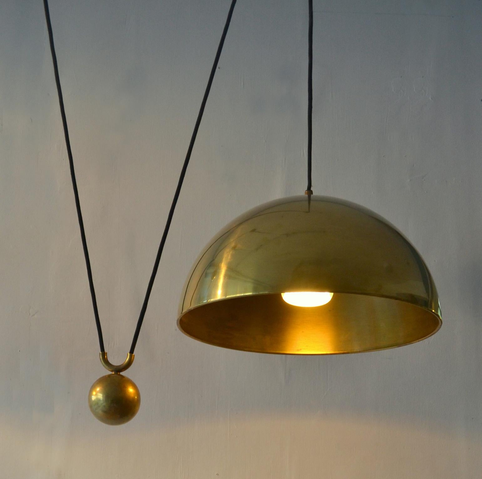 Counterbalance pendant 'Posa' by Florian Schulz side weight. Strong and minimal pendant in a high quality brass moves smoothly up and down due to the solid brass counterweight. The brass is coated. 
Excellent timeless design of a very functional