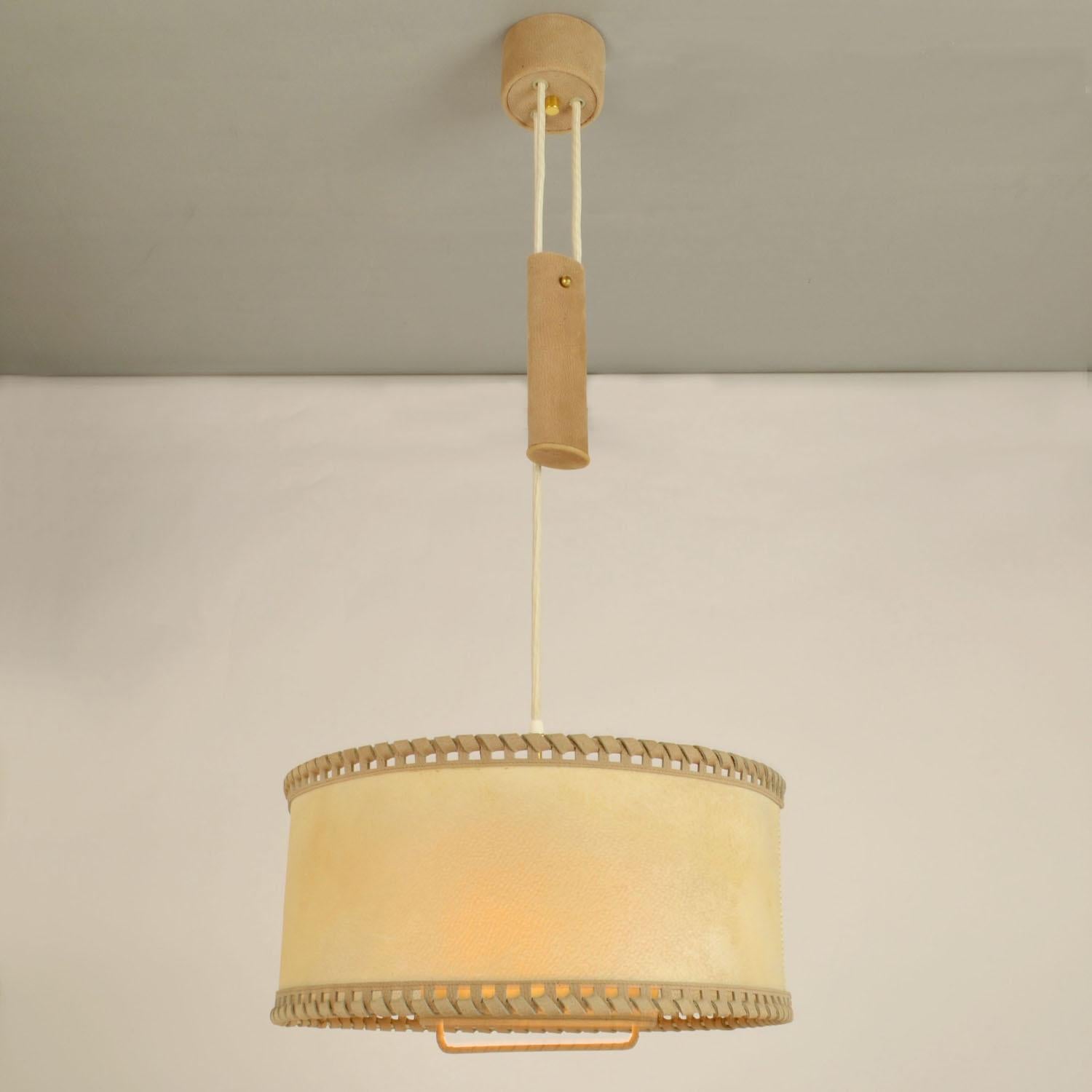 Counterbalance pendant with centre weight. High quality hand made drum shade in real moves smoothly up and down on the counterweight, guided by a handle. The drum shade is made of parchment or vellum which is very strong and is hand stitched and