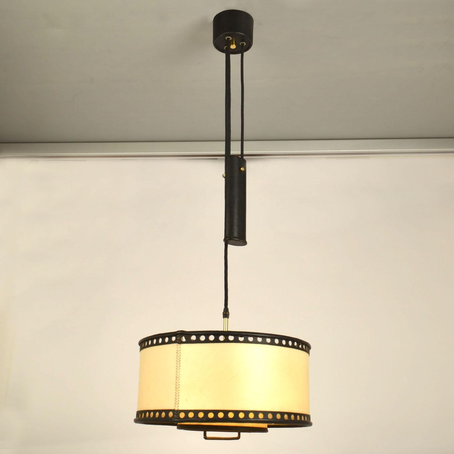 Counterbalance pendant with centre weight. High quality hand made drum shade in real parchment and black leather moves smoothly up and down on the counterweight, guided by a handle. The drum shade is made of parchment or vellum which is very strong