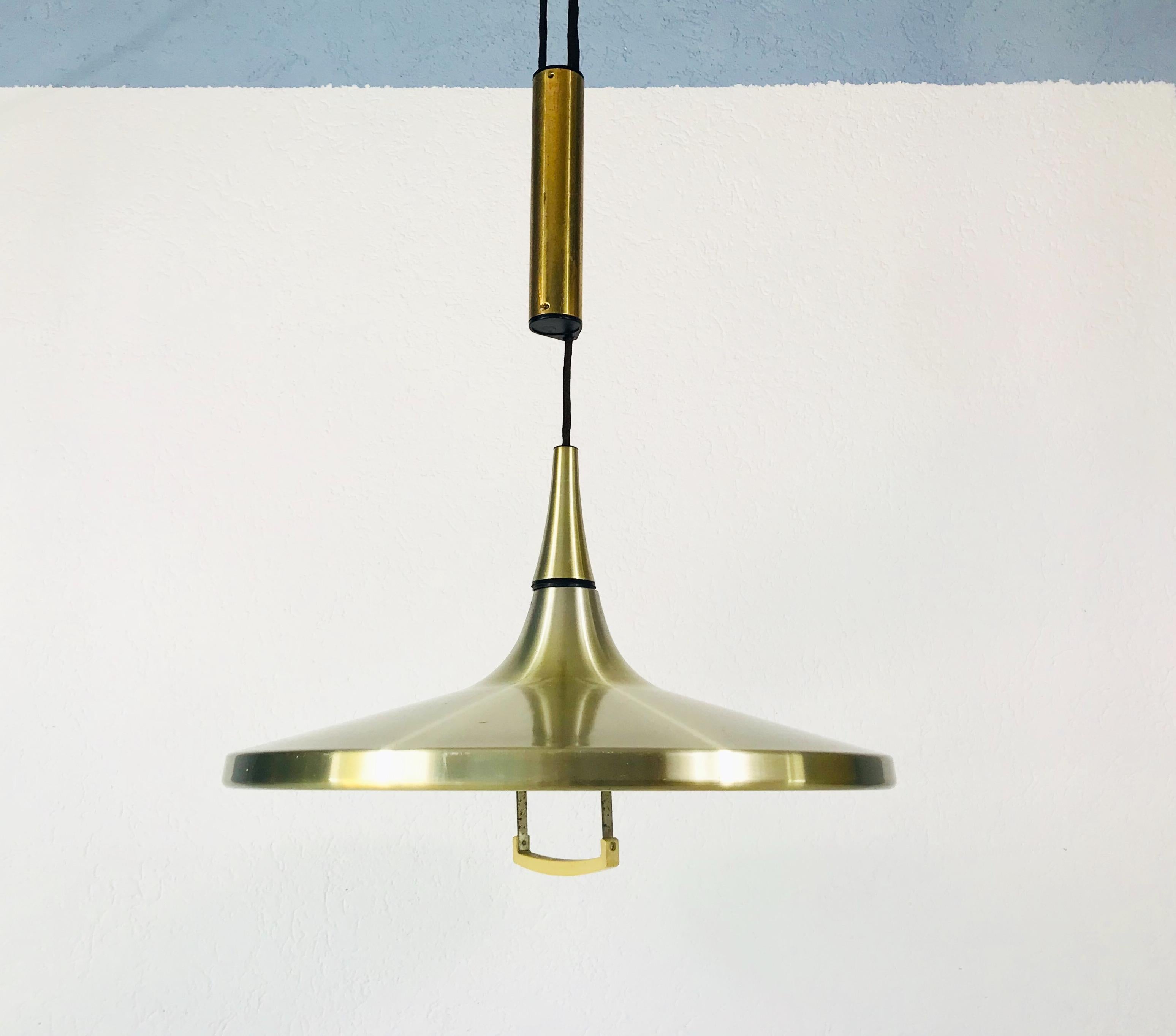 A counterweight ceiling lamp by Erco made in Germany in the 1970s. It has a heavy counterweight which is secure to the black rope. The lamp shade is made of aluminum and has a plastic handle below. The shape of the lamp is similar to a witch
