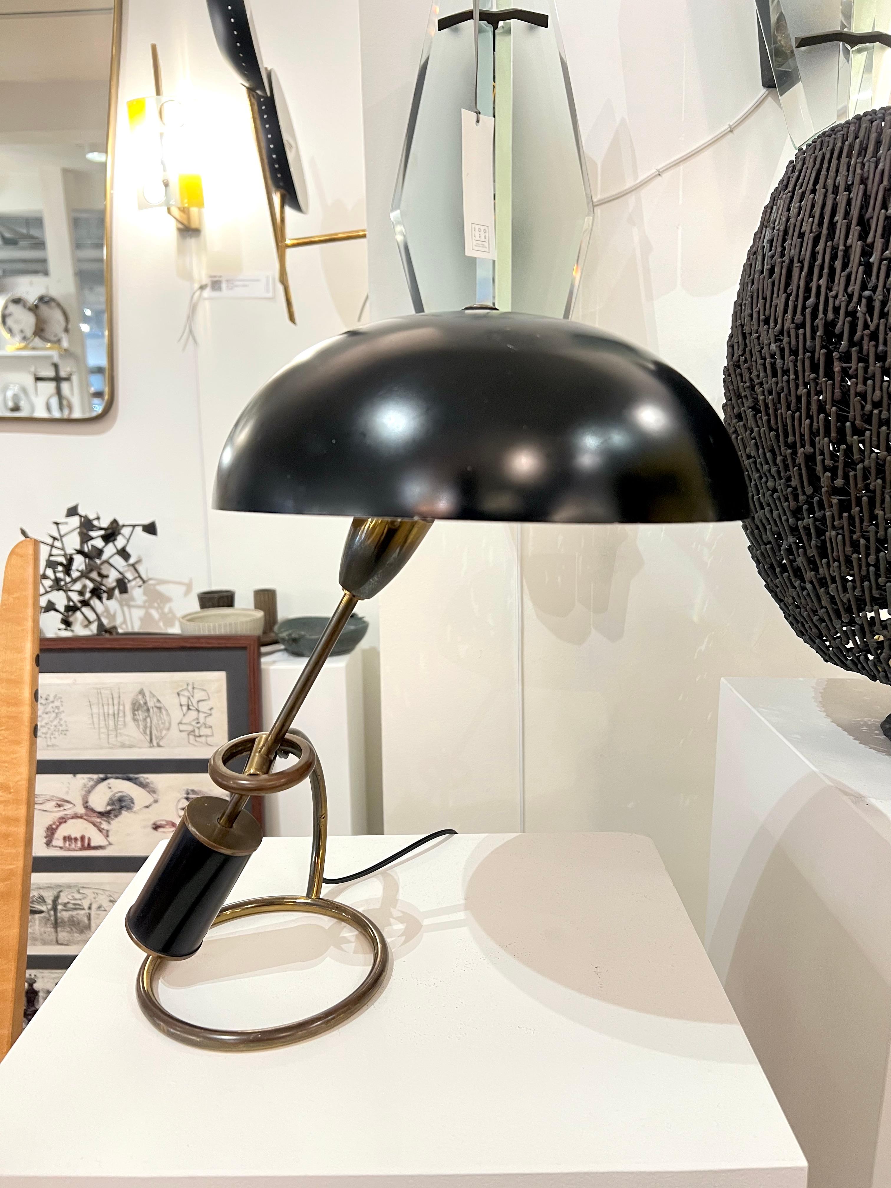 Lámpara de sobremesa negra contrapesada de latón, de Angelo Lelli para Arredoluce. Italia, años 50.
Presenta una base de latón y una pesa esmaltada en negro y una pantalla de aluminio. Brazo de contrapeso y pantalla articulados para varios ángulos y