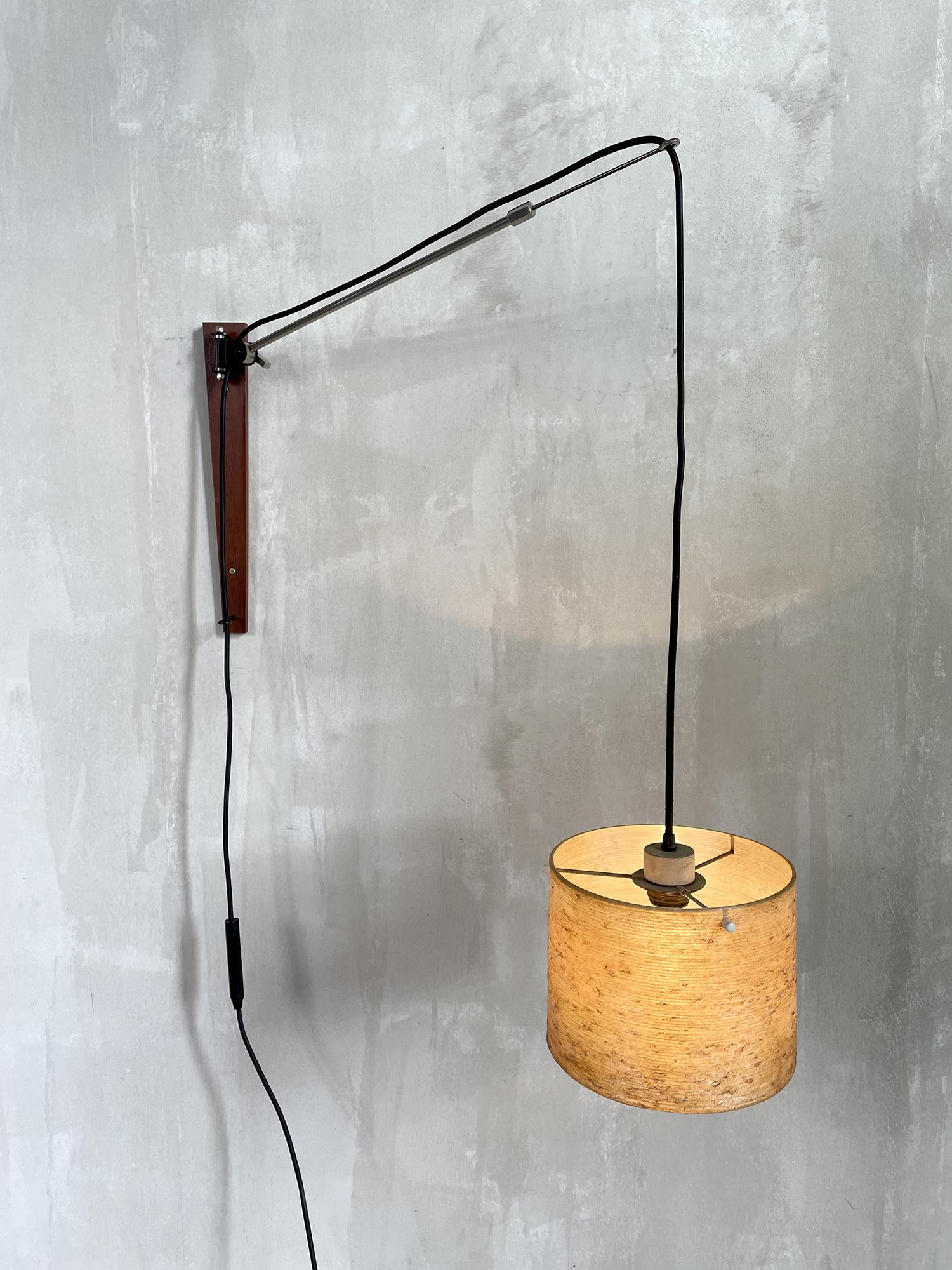 Counterweight wall lamp, Sweden 1960. Teak plate, chrome metal arm, black fabric thread. The reflector is made of braided resin. The height is adjusted by sliding the wire and by adjusting the arm, in height and in length.
Very good condition. 
At